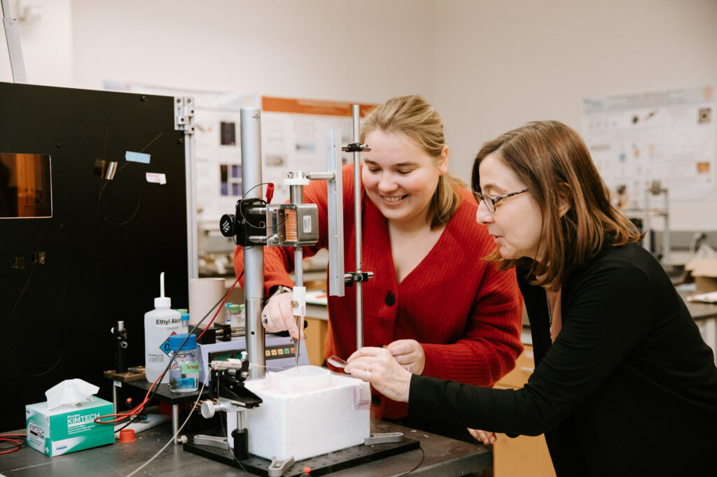 Professor Lois Pollack and a Ph.D. student work on a piece of equipment in an AEP lab.