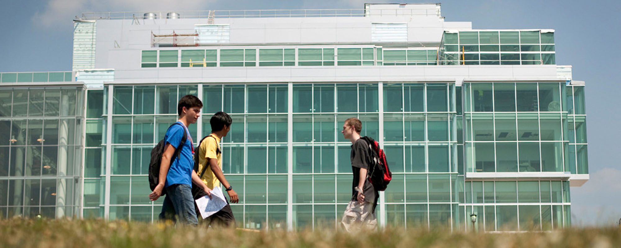 students walk by the outside of the Physical Sciences Building