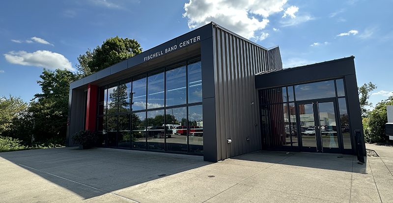 A rectangular building with a front side that is mostly windows.