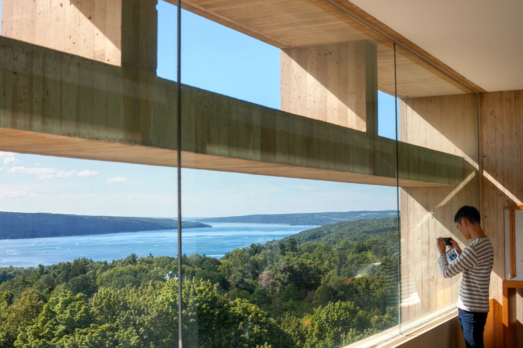 Student views Cayuga Lake from high up in the Johnson Museum