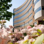 Curving architecture of Rhodes Hall with blooming flowers in foreground