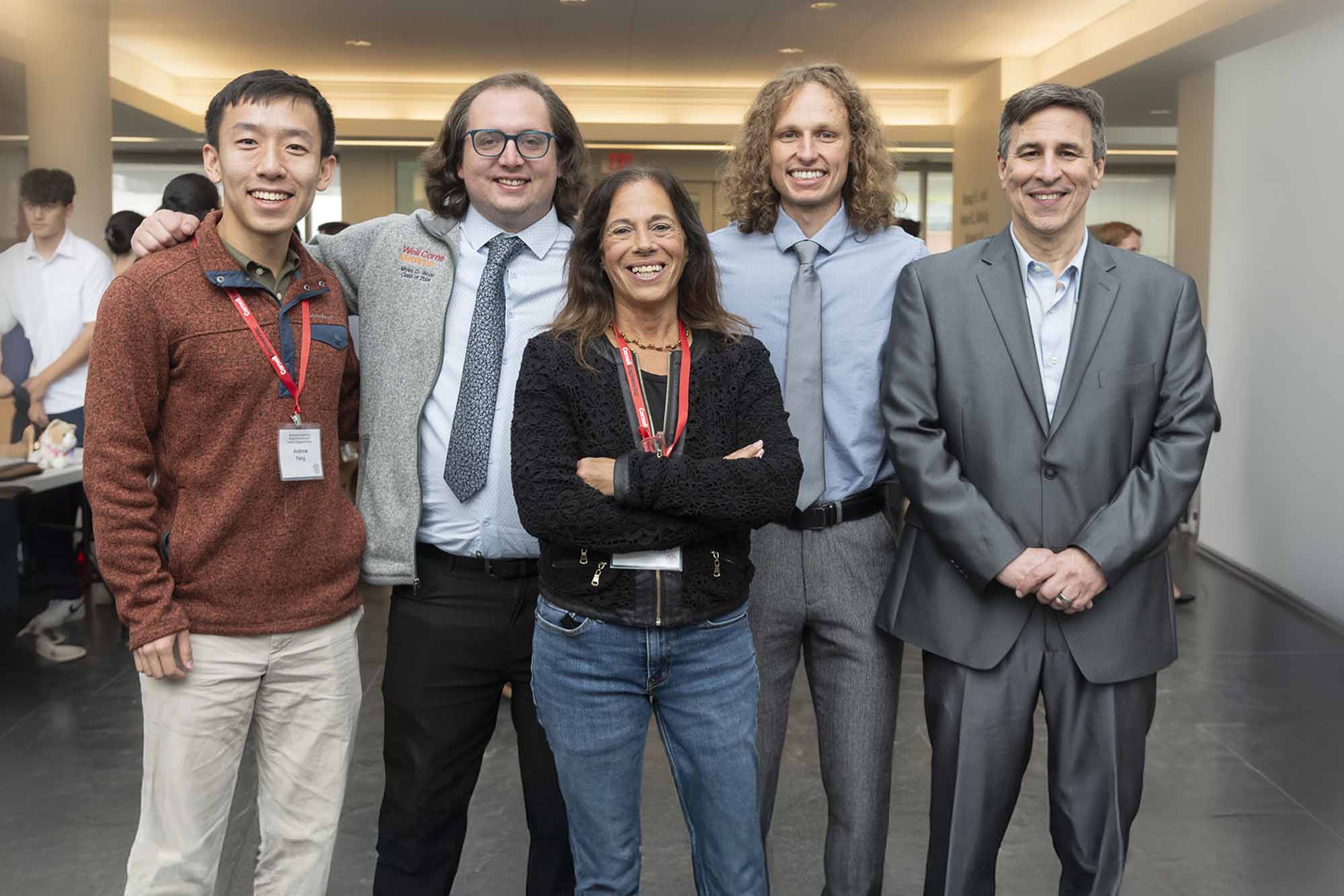 Three students in business attire pose with faculty advisors at the BME Industry Day M.Eng. Showcase.