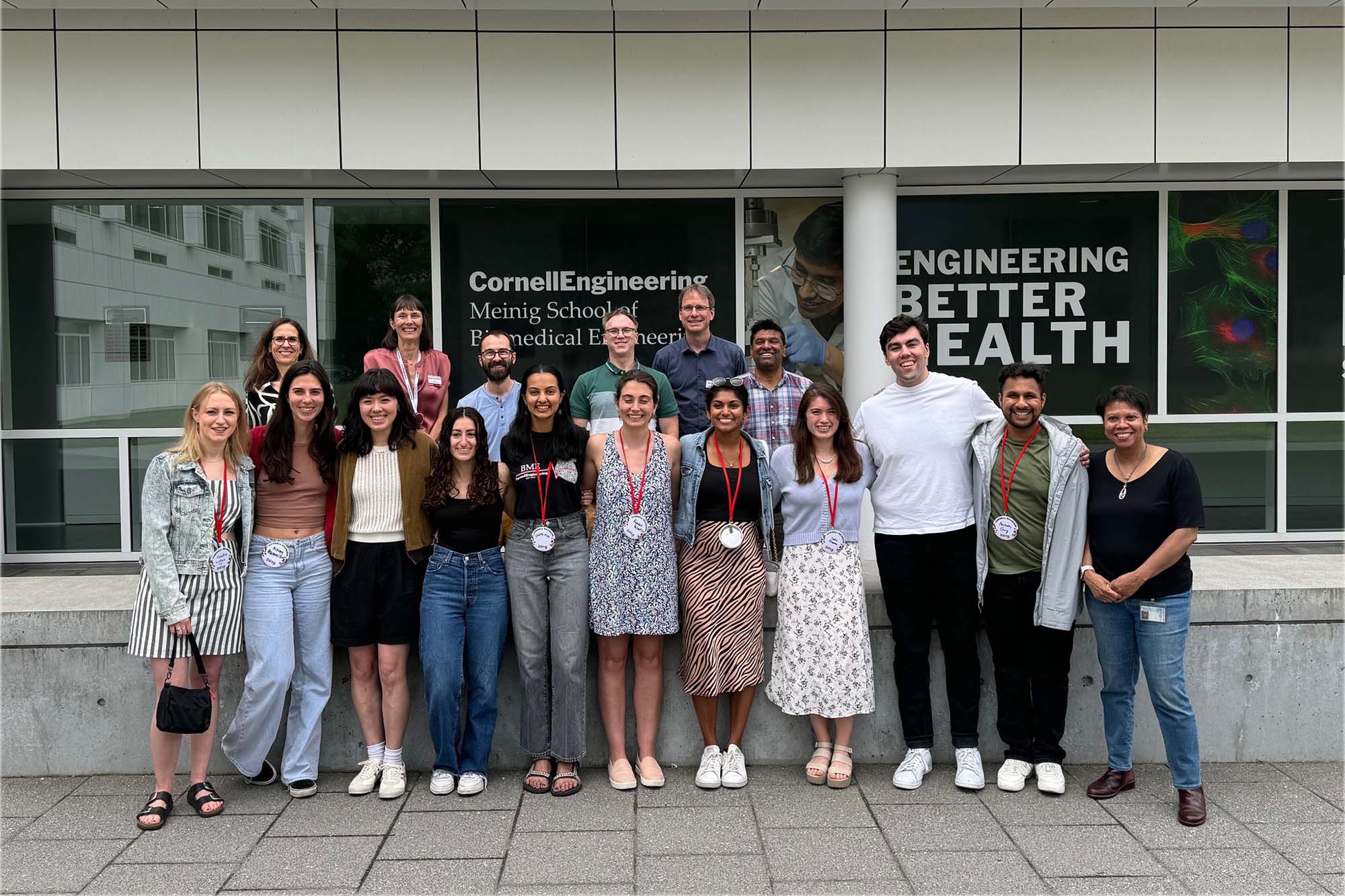 Members of the Class of 2019 (with faculty) stand together outside Weill Hall in 2024