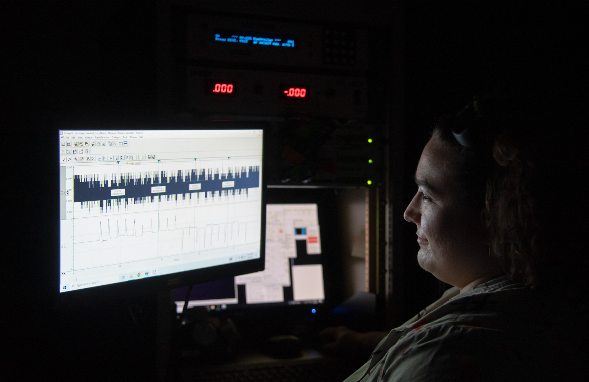 Graduate student in lab interprets optical imaging spectra on computer screen.