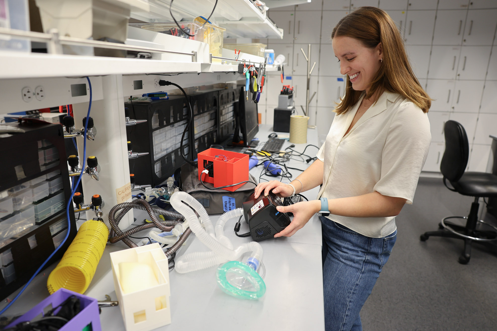 Undergraduate student Emma Taigounov at bench working on senior design project, a continuous positive airway pressure (CPAP) device accessory in Weill Hall.
