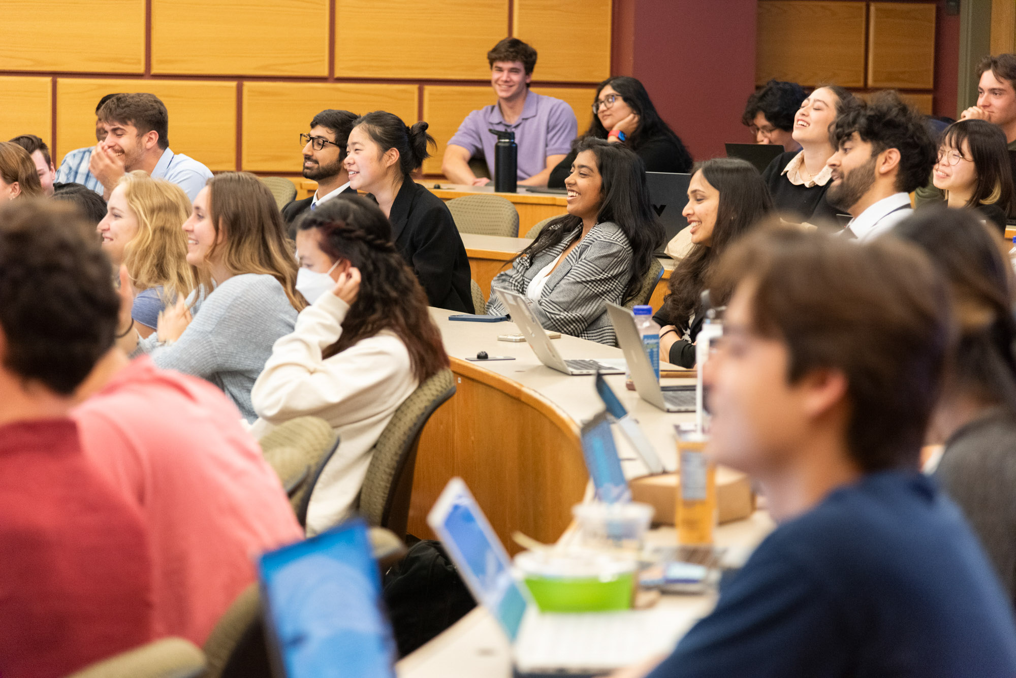 Students sitting in a classroom laugh during the BME senior showcase
