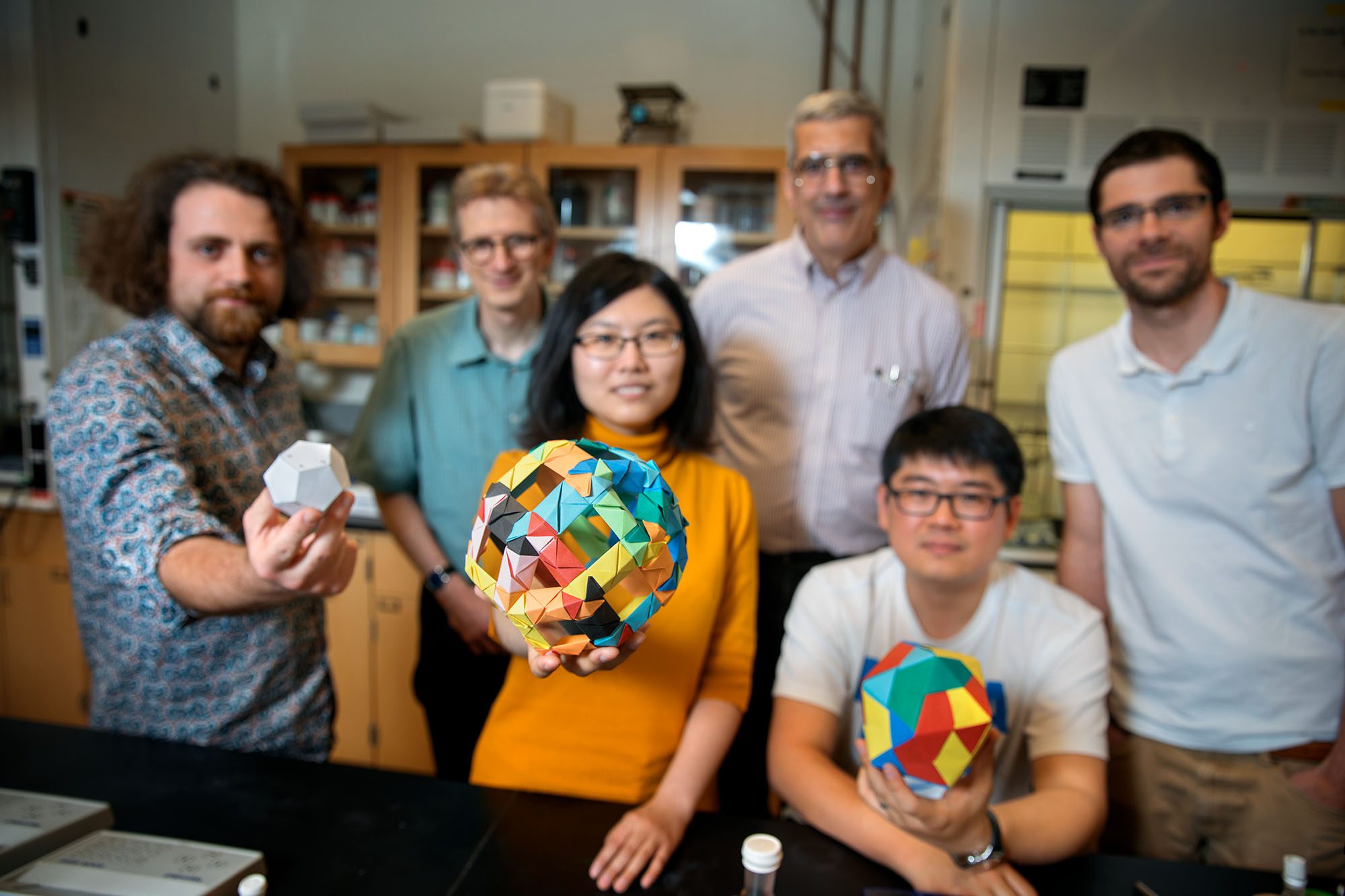 Peter Doershuck with researchers and dodecahedron models in Wiesner lab