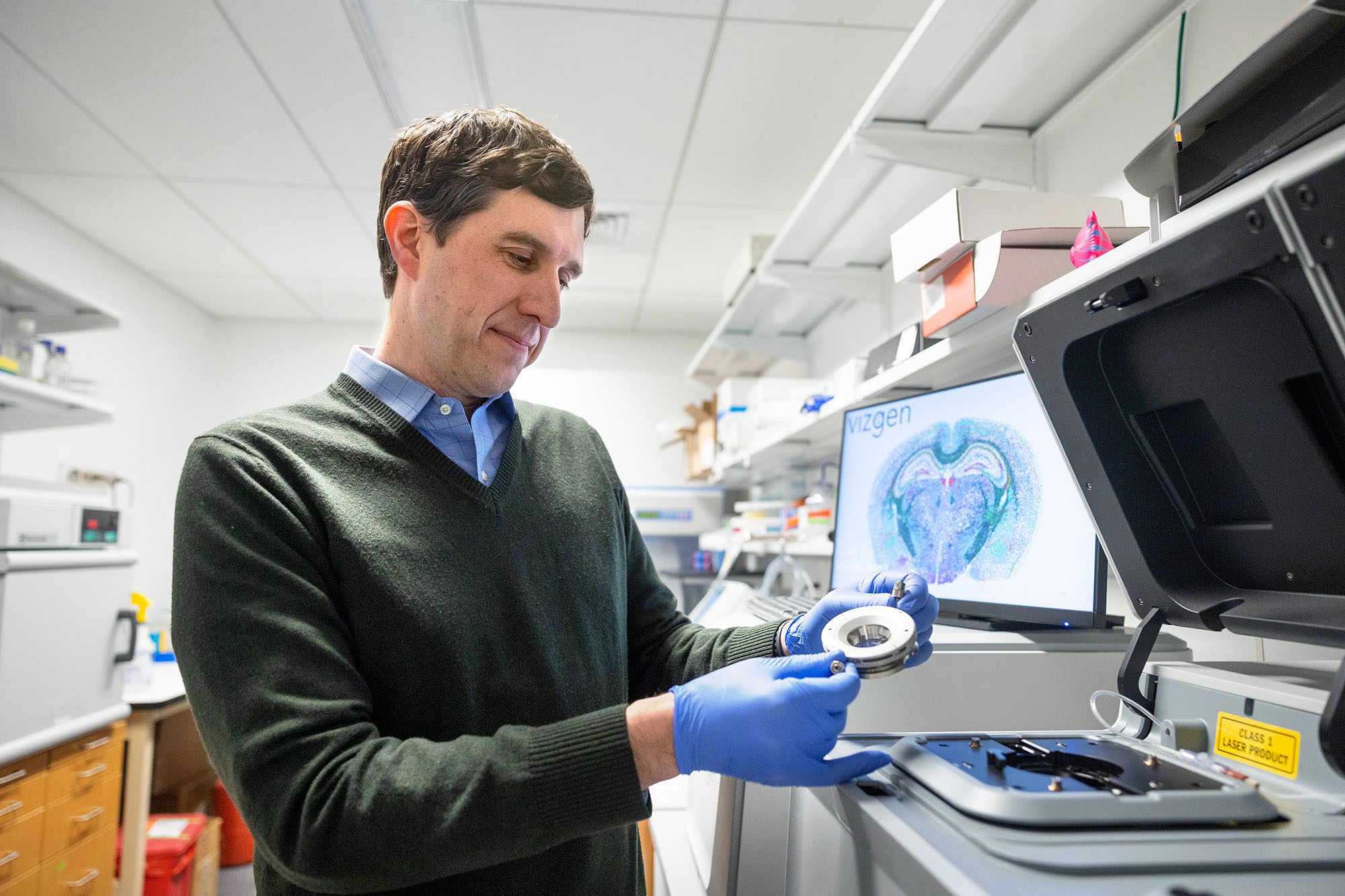 Ben Cosgrove in lab holding technology for chronic fatigue research