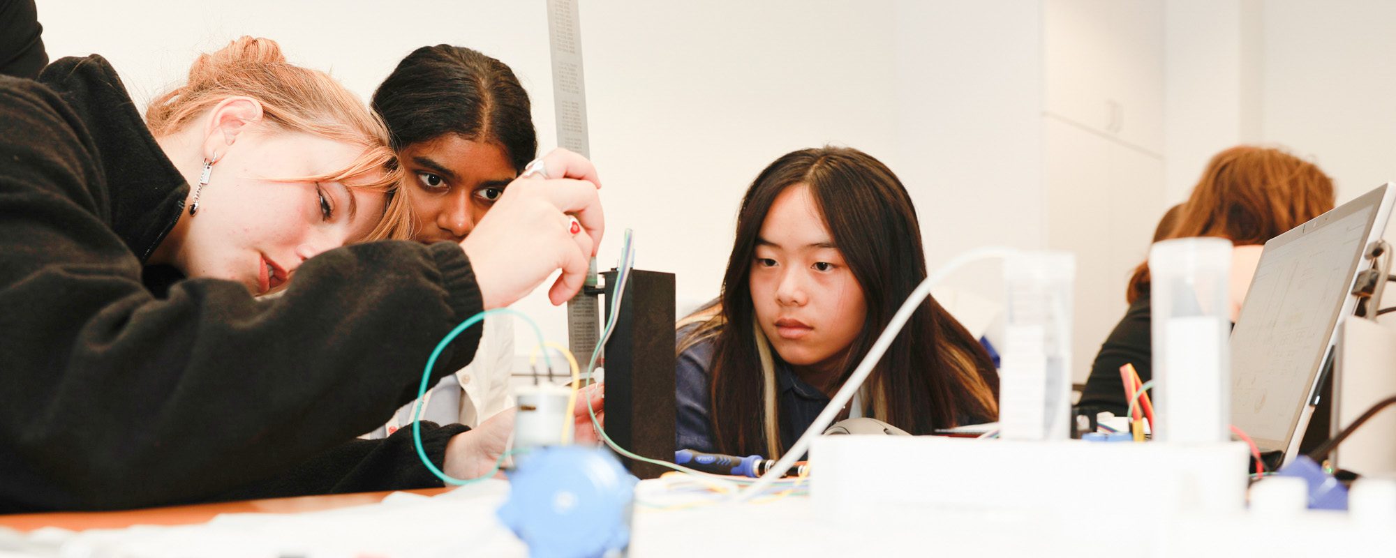 Three students work on a project in the lab.