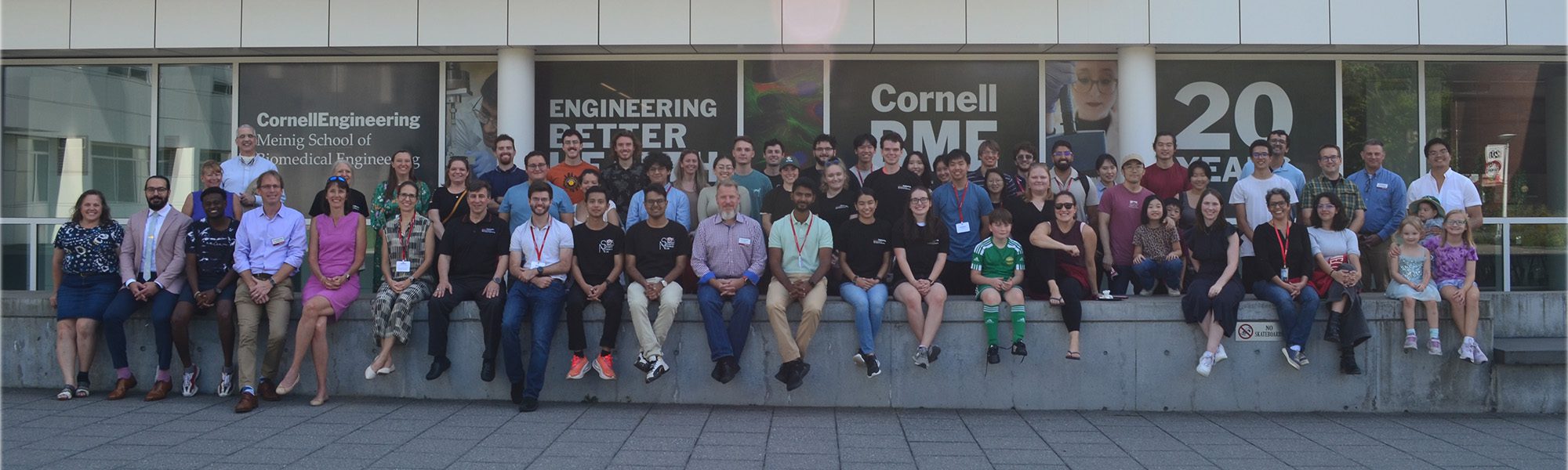 Faculty, staff, alumni, and friends sit together in front of Weill Hall for 20 year celebration.
