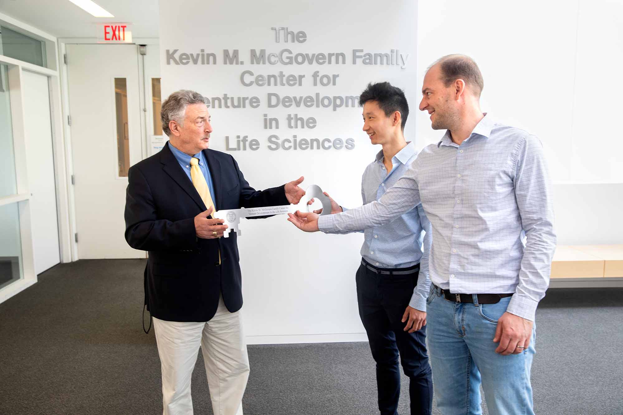 Lou Walcer hands key to Iwijn DeVlaminck in Weill Hall Atrium McGovern Center.