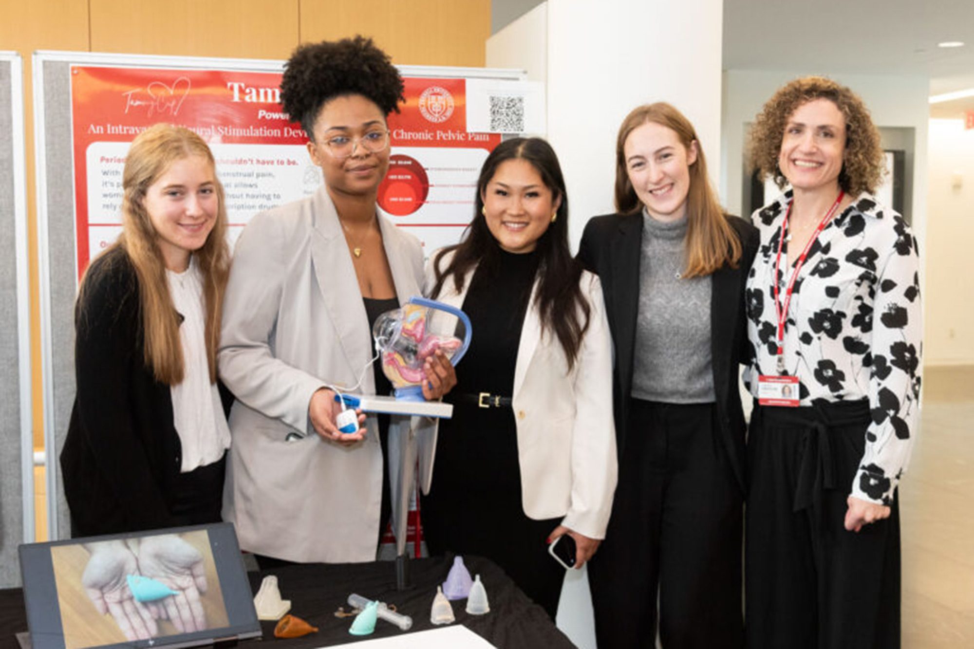Five students standing in front of their project showcase