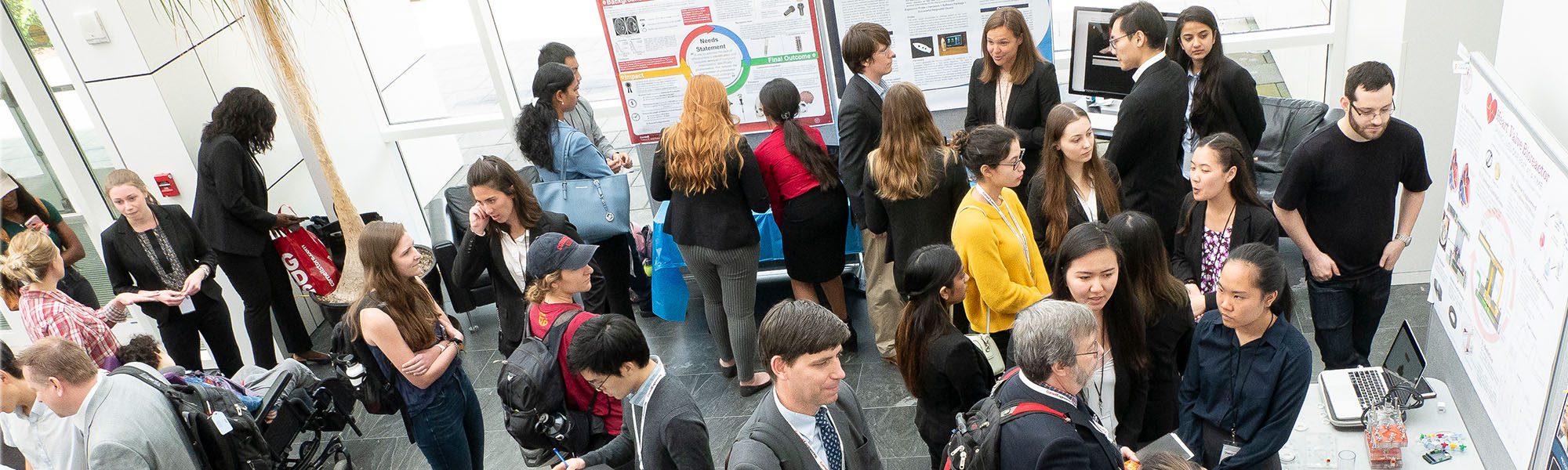 M.Eng. students, faculty, and guests talk and share posters in Weill Hall atrium for industry and engagement day.