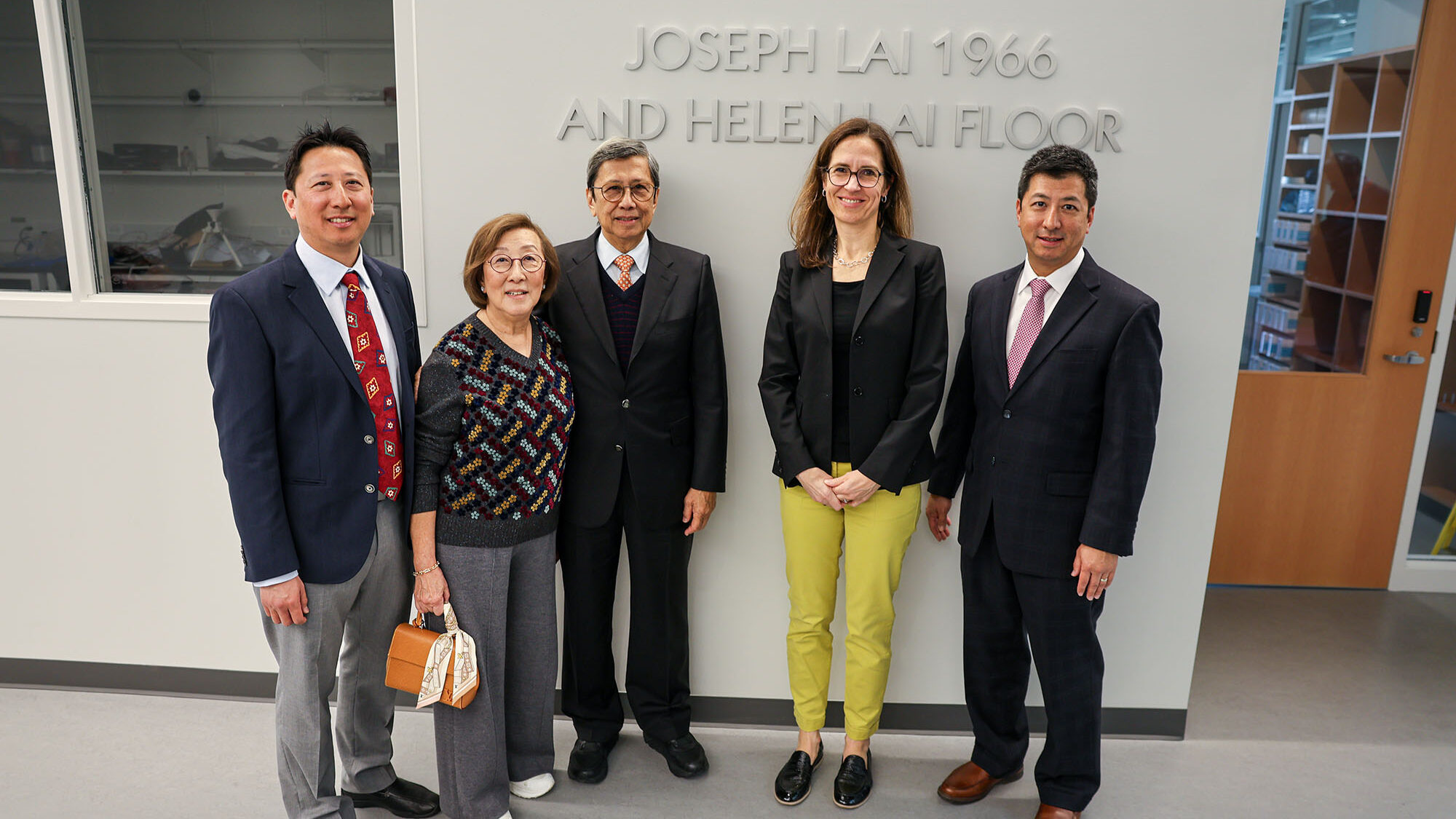 Joseph and Helen Lai and family stand with Claudia Fischbach in Tang Hall teaching space.