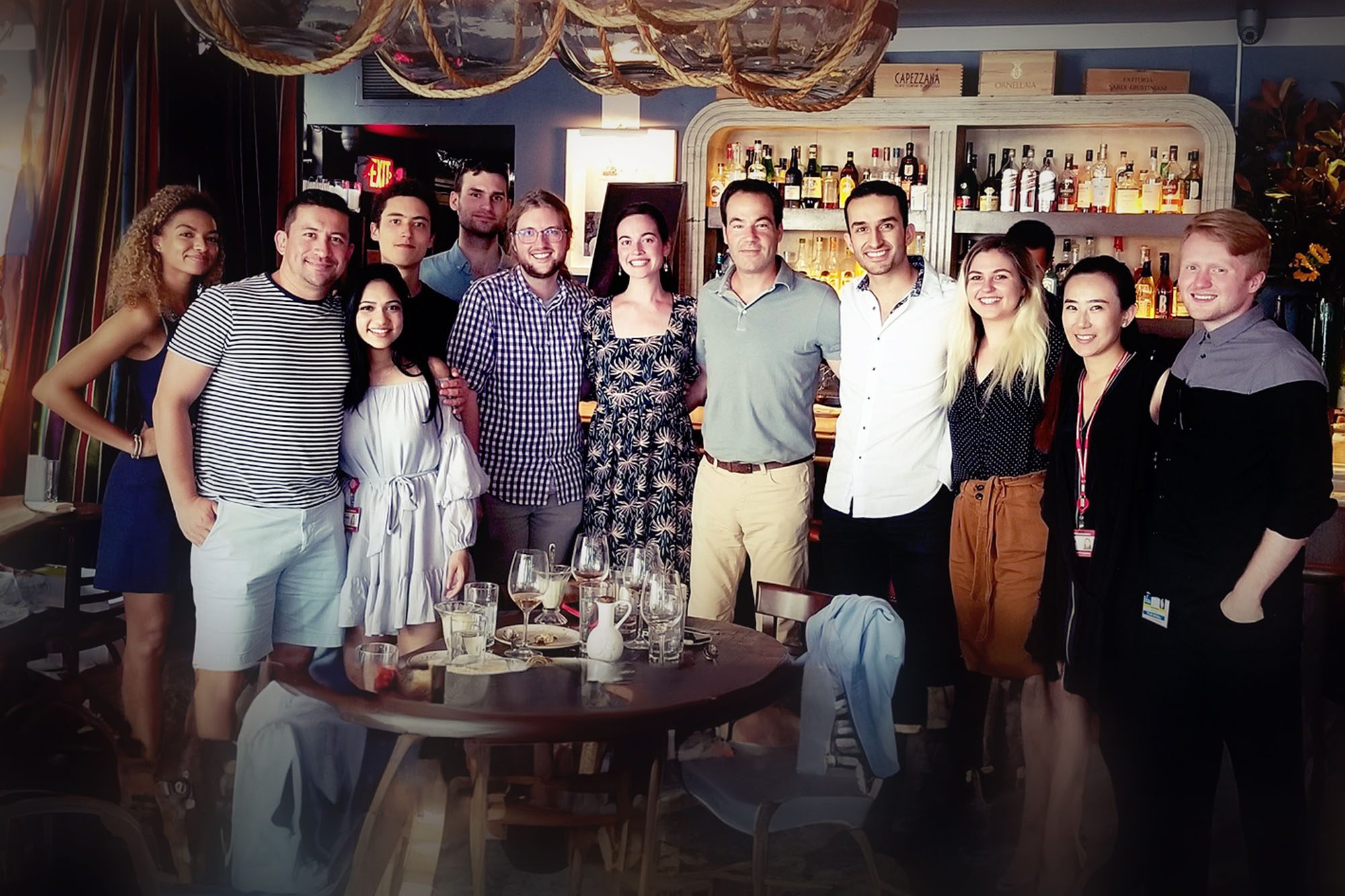 Jason Spector stands with PhD clinical immersion students at a restaurant in New Yor City.