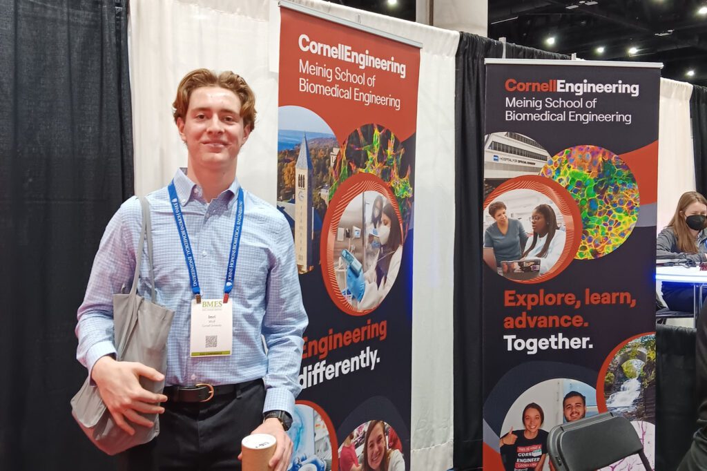 Ithaca High School junior Imri Wolf stands at the biomedical engineering conference booth.