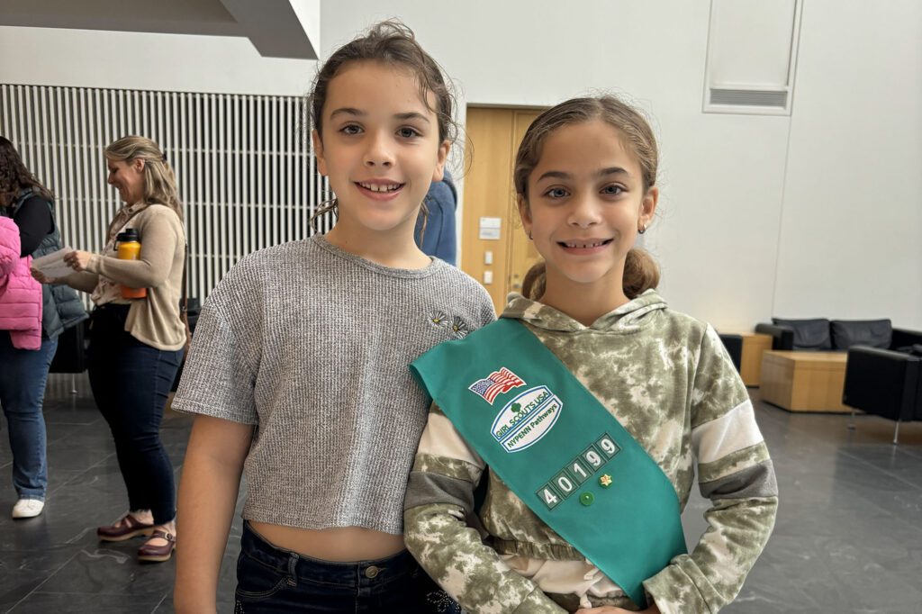 Two girl scouts stand together in Weill Hall Atrium.