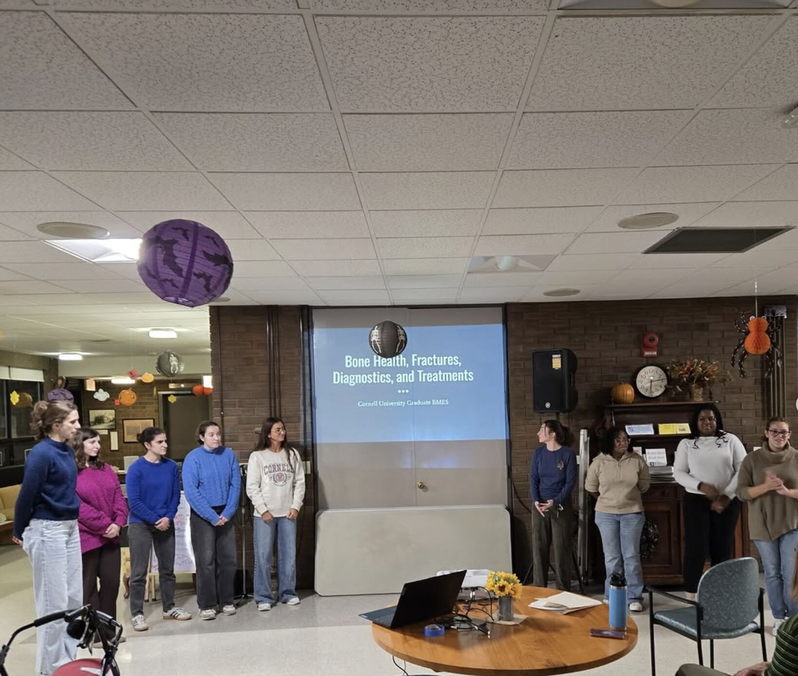 Maddie Slavett and fellow graduate students present on bone health to McGraw house residents in a BMES outreach event.