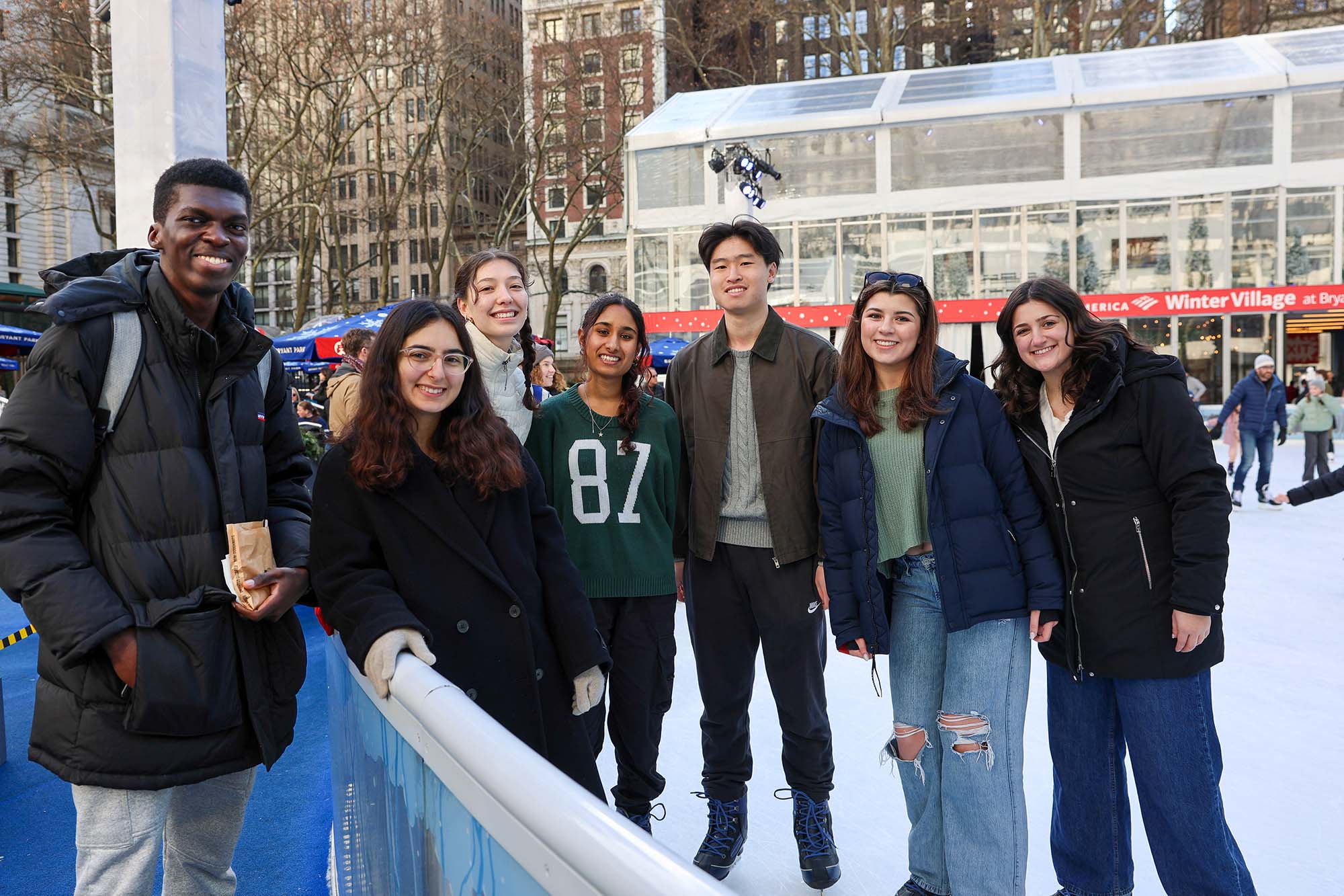 Undergraduate clinical immersion students pose together on ice skating rink in park in New York City.