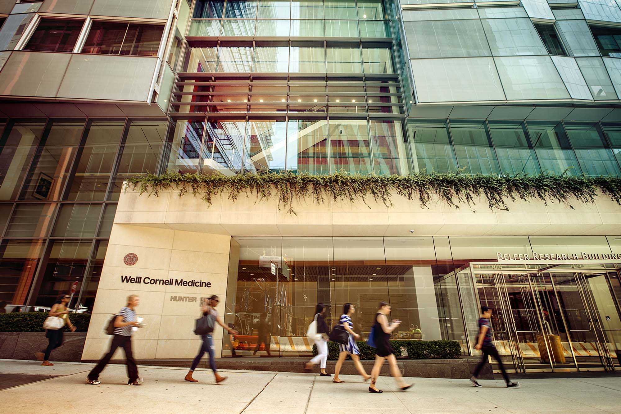 Weill Cornell Medicine exterior and sidewalk with people walking by.