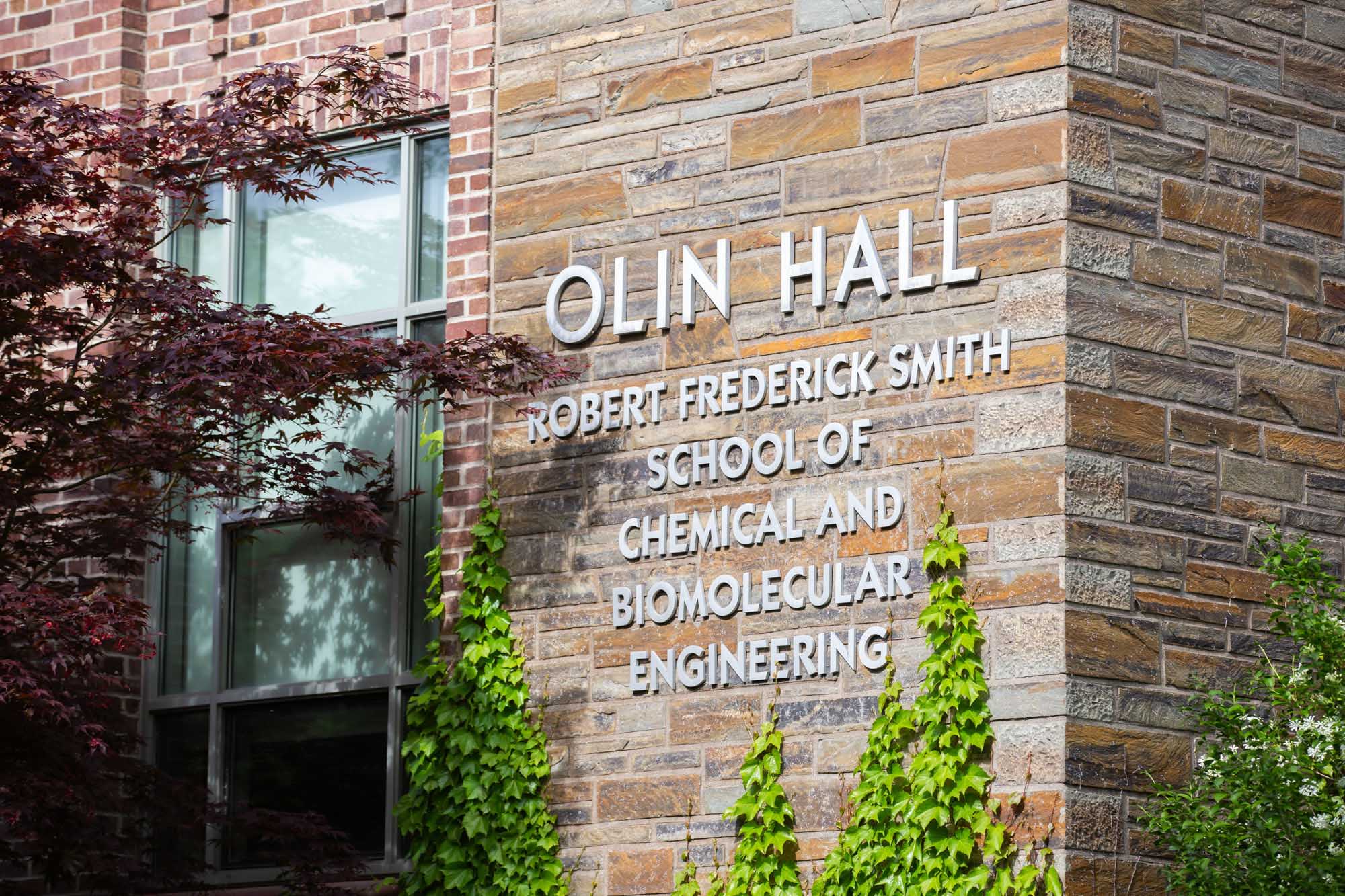 Exterior of Olin Hall in the summer with sign reading Olin Hall Robert Frederick Smith School of Chemical and Biomolecular Engineering.