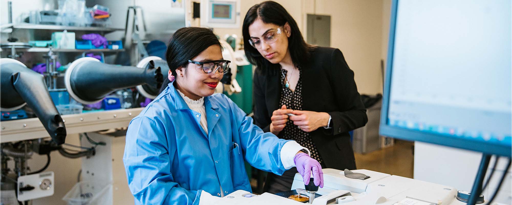 Vibha Kalra works with a student in Olin Hall lab.