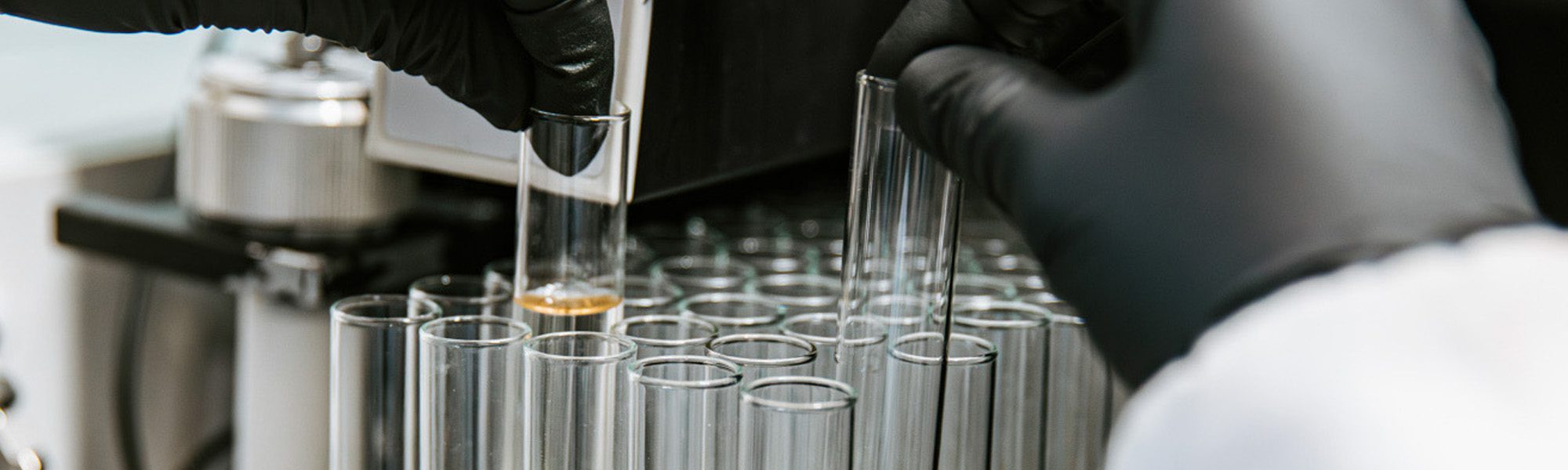 a researcher in a lab coat conducting an experiment in the Alabi Lab.