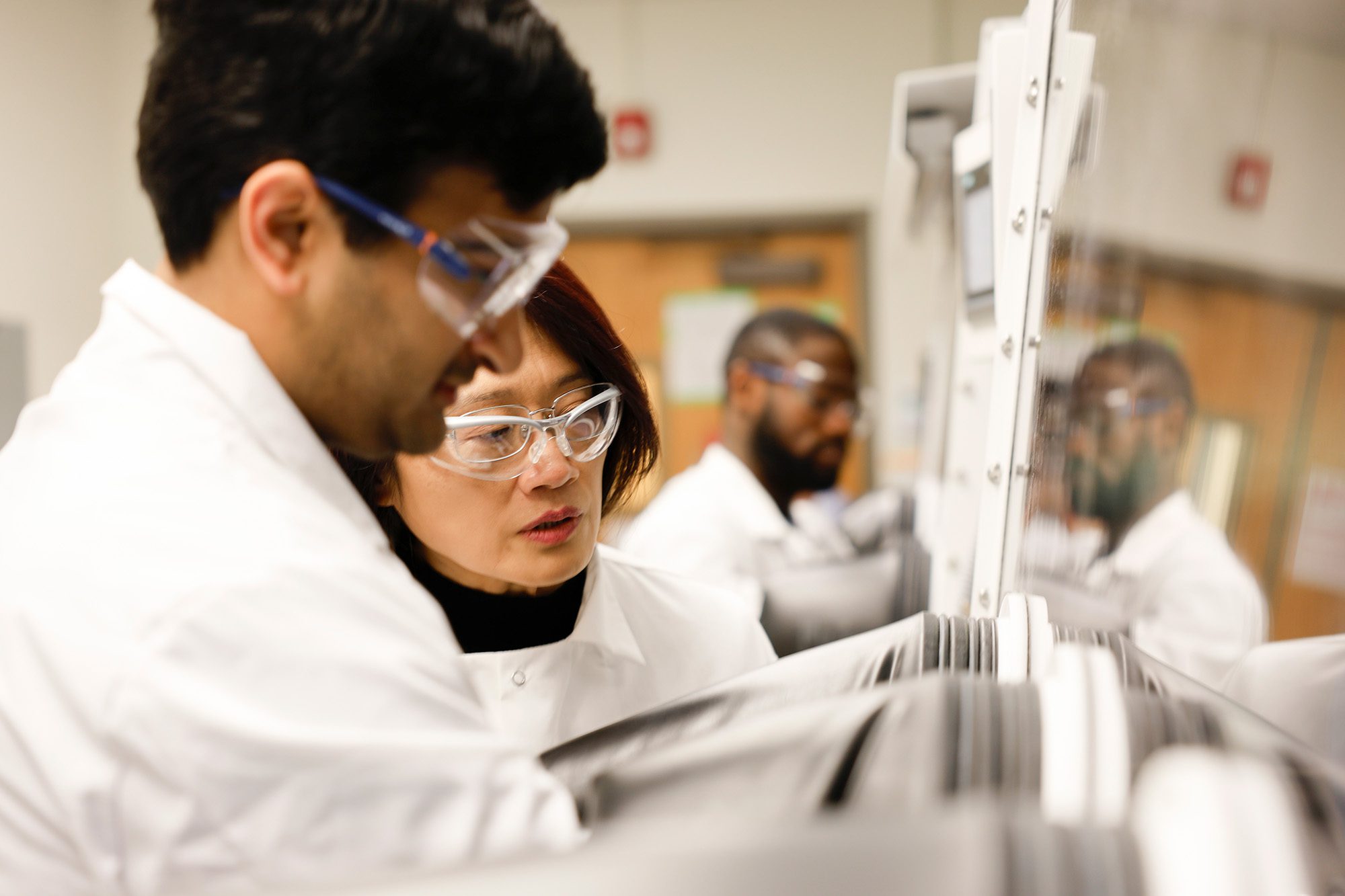 Qiuming Yu and a research student in the Yu Research Lab in Olin Hall fume hood.