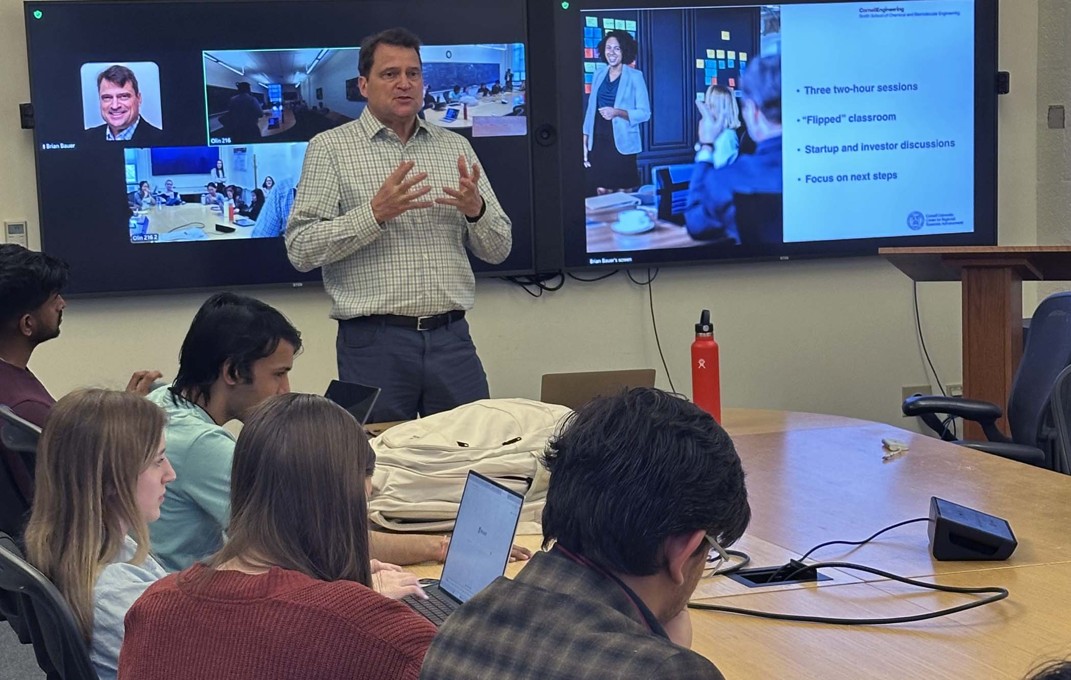 Brian Bauer stands before graduate students teaching about entrepreneurship for CBE Women group.