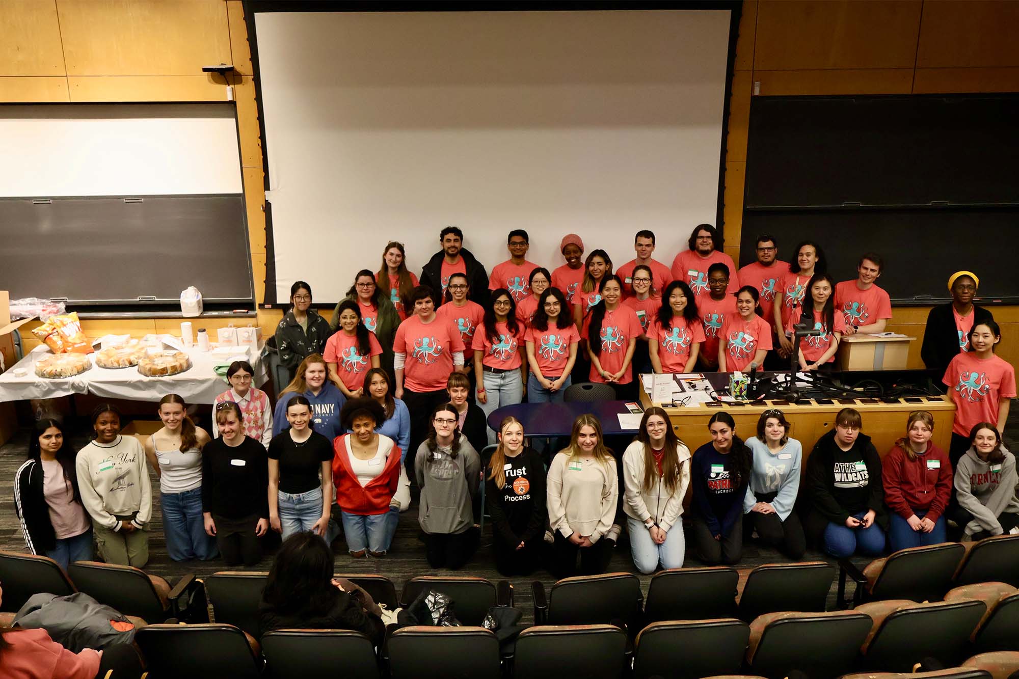 Group of graduate students stand together posing for CBE Women Outreach event in Olin Hall.