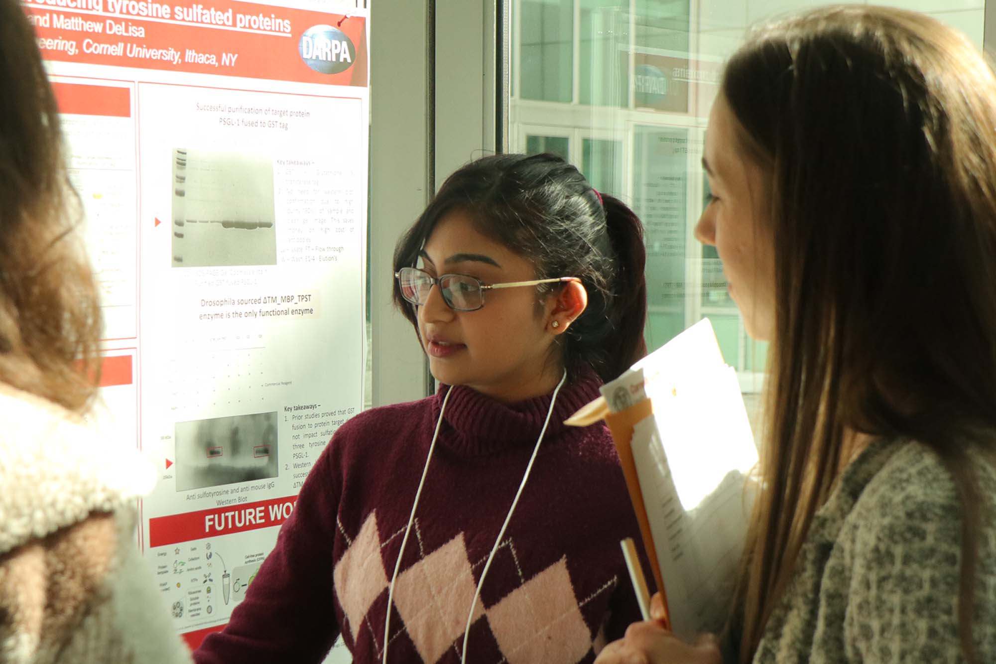 A graduate student discusses her reserach poster with Marsha Kowal at a Chegsa-organized graduate research symposium.