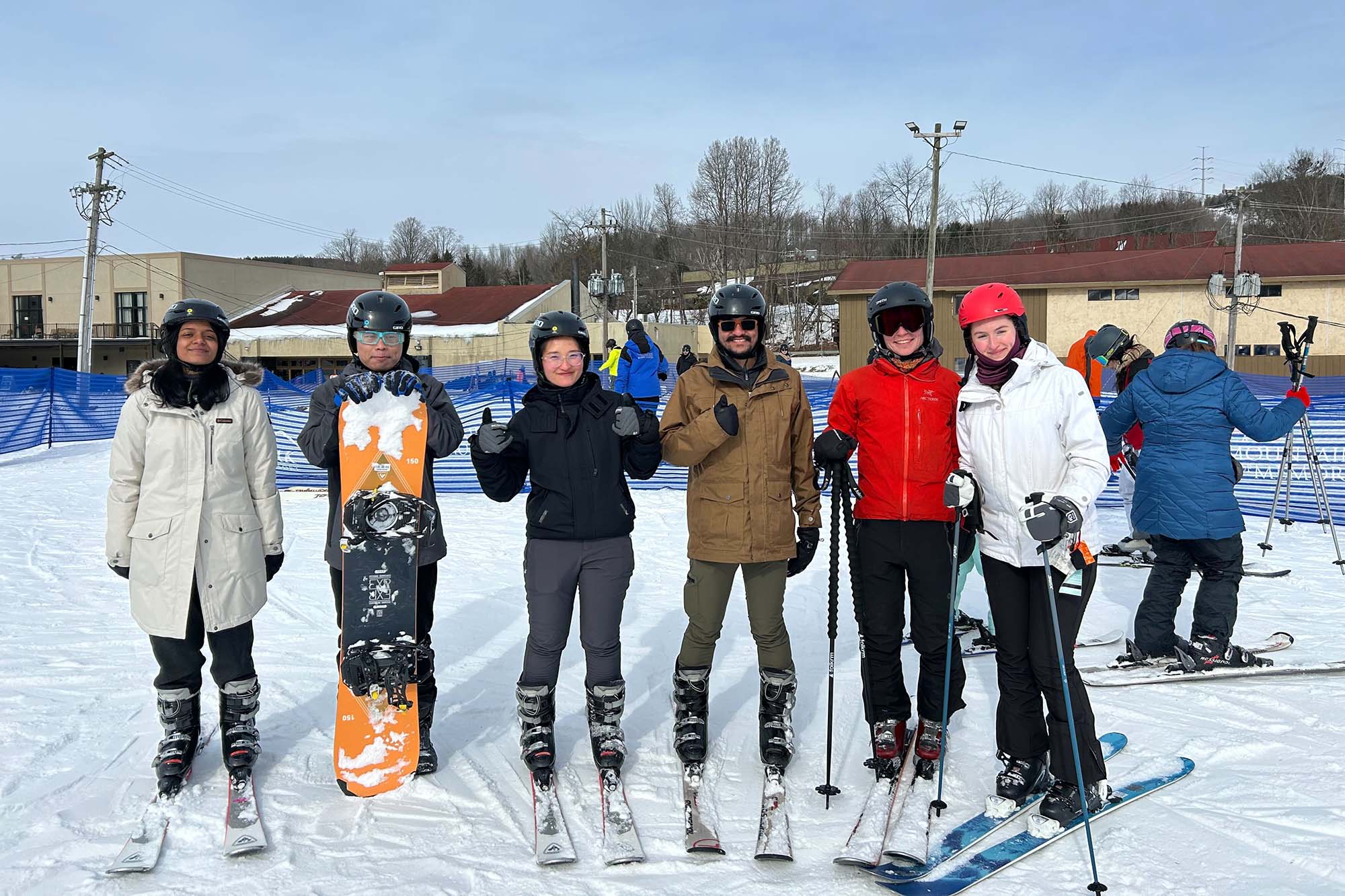 Graduate students stand together outside in winter ski gear for skiing event at Greek Peak.