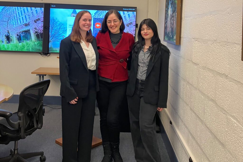 Julia Salatti and Alina Chisti stand with faculty Eda Celik in Olin Hall classroom after presenting their M.Eng. project final presentation.