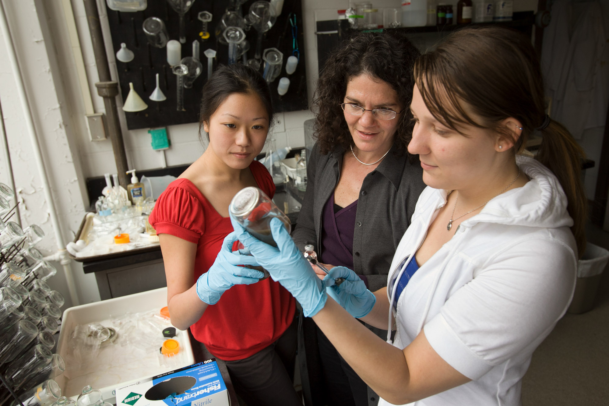 Professor Ruth Richardson watching two students conducting an experiment in the Richardson lab