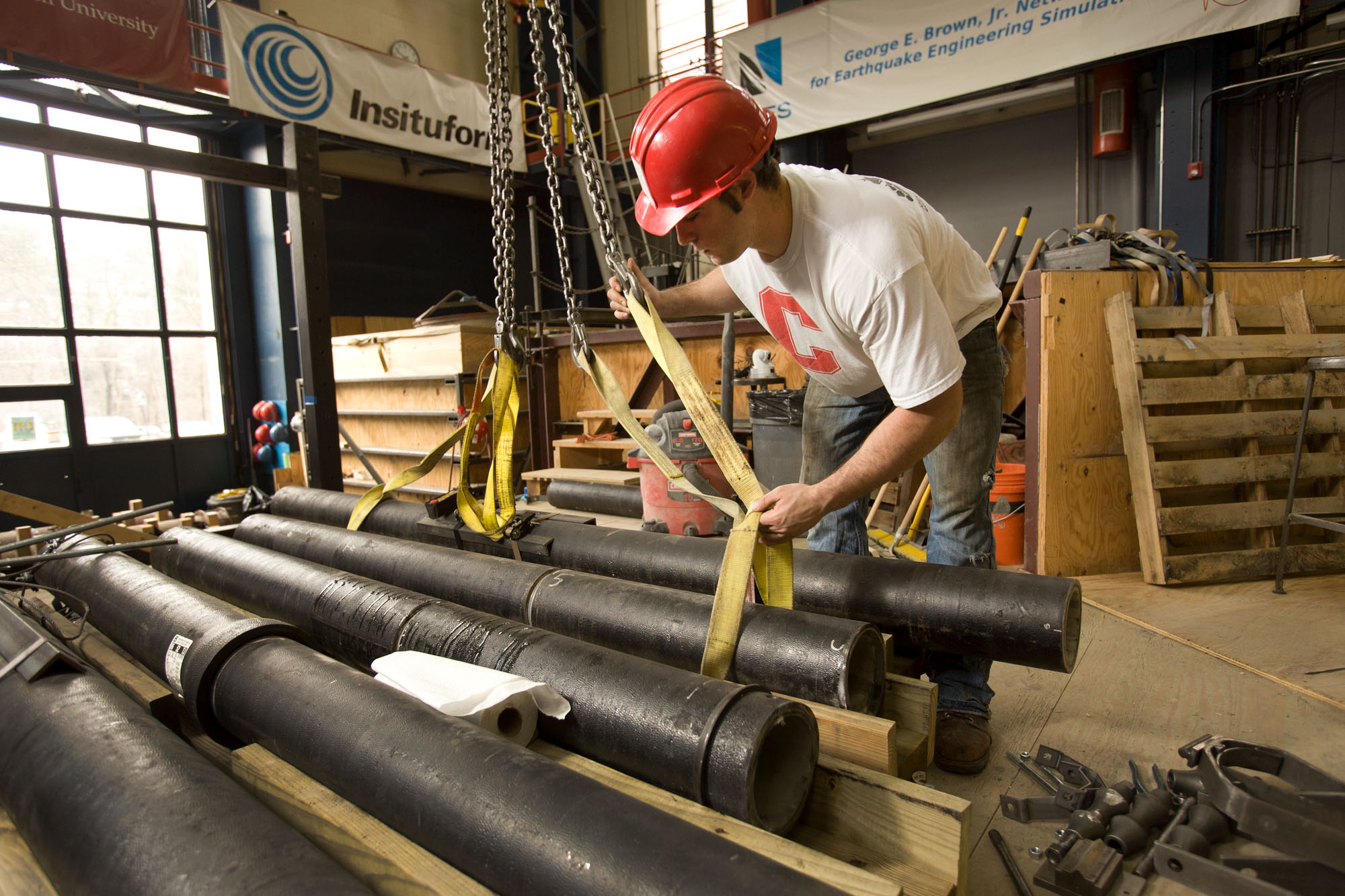 Student wearing a hard hat working in the earthquake engineering simulation lab
