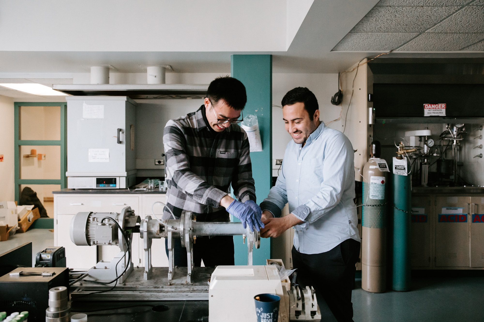 Two researchers work together on metal device