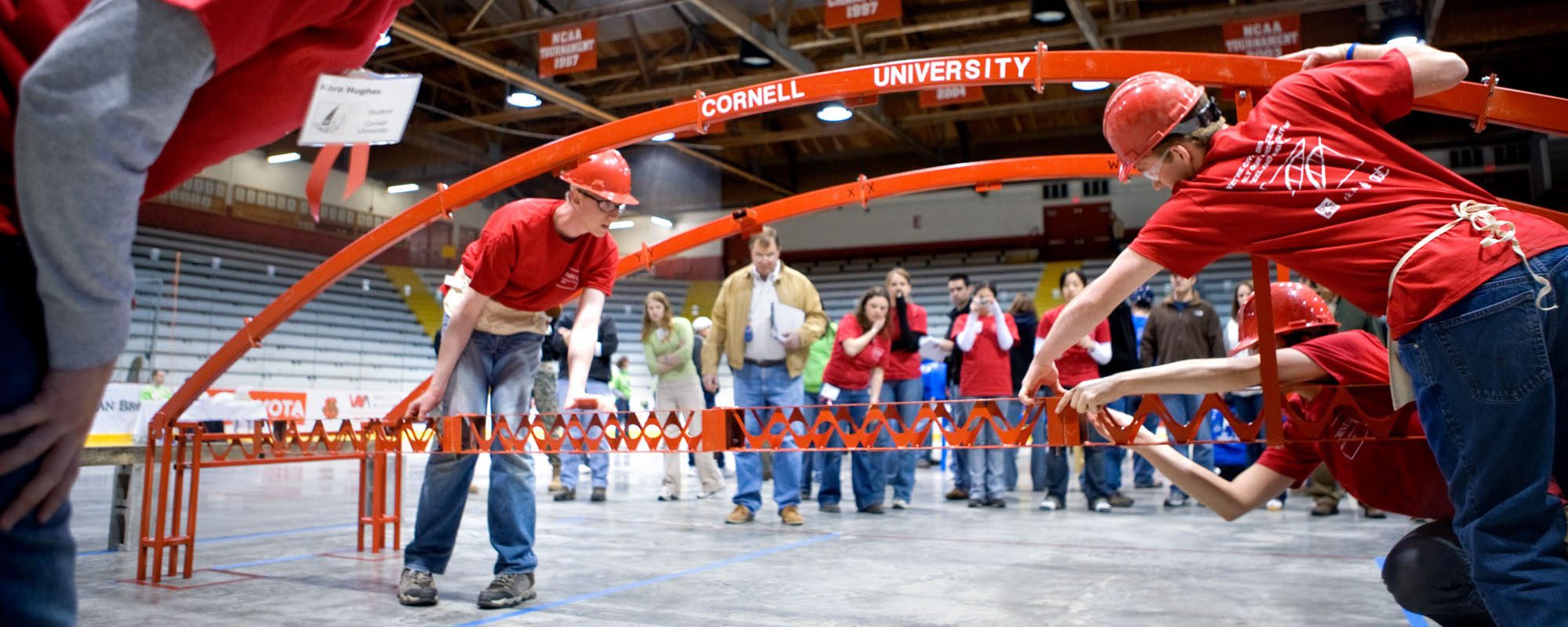 students hold a bridge arch