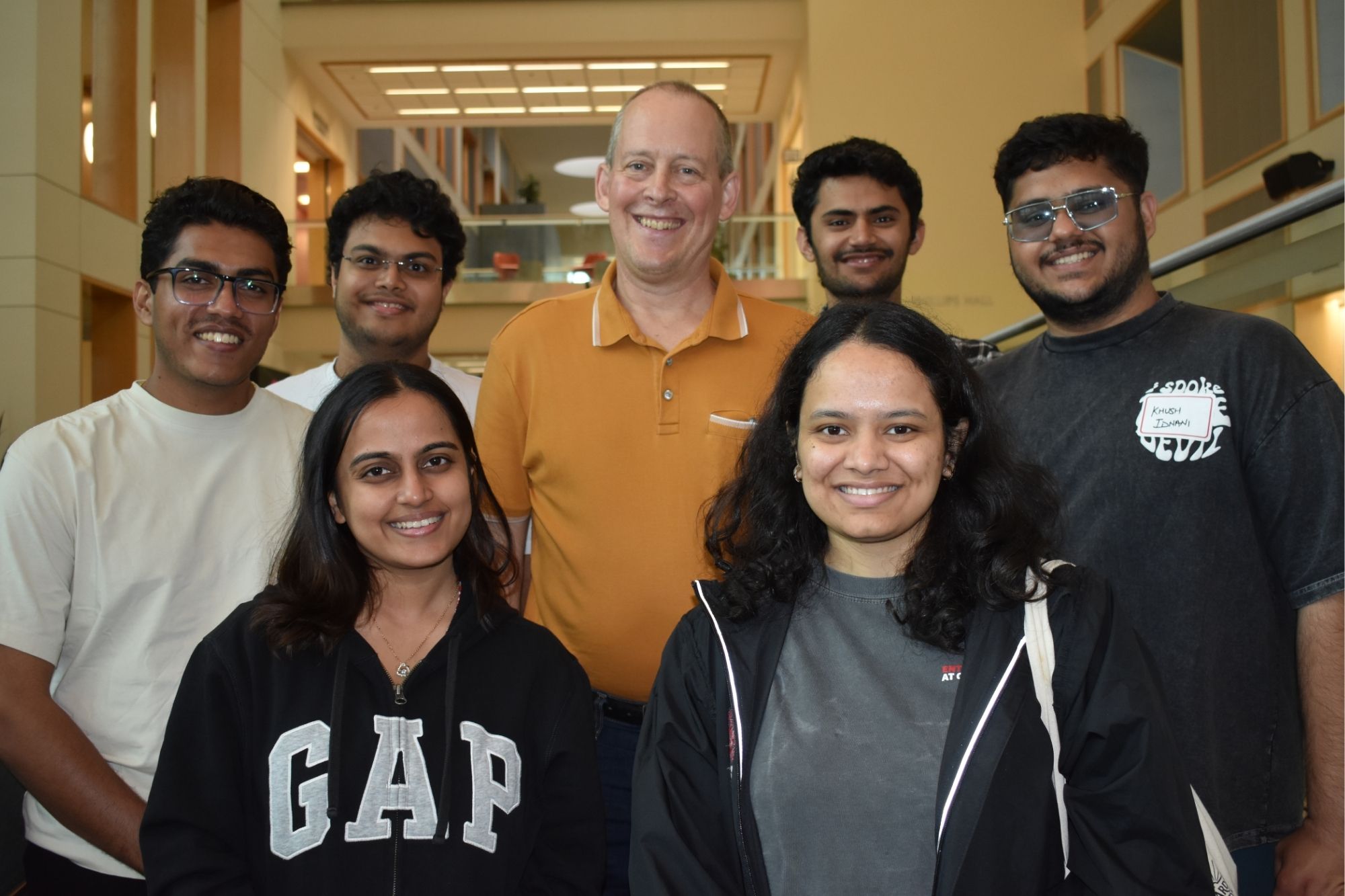 Alumni standing with a faculty member and posing for a photo in Duffield hall during CEE Reunion weekend 2025
