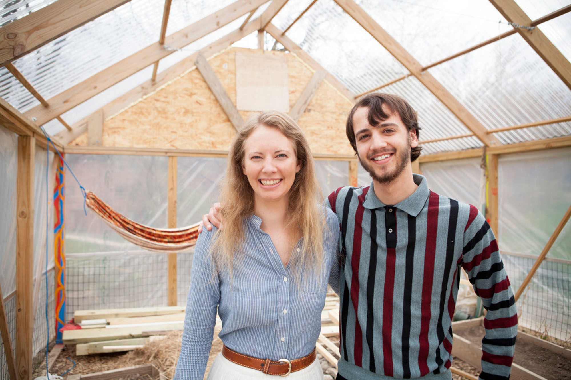Two EAS students stand inside the Ecology House Contest construction they were part of creating.