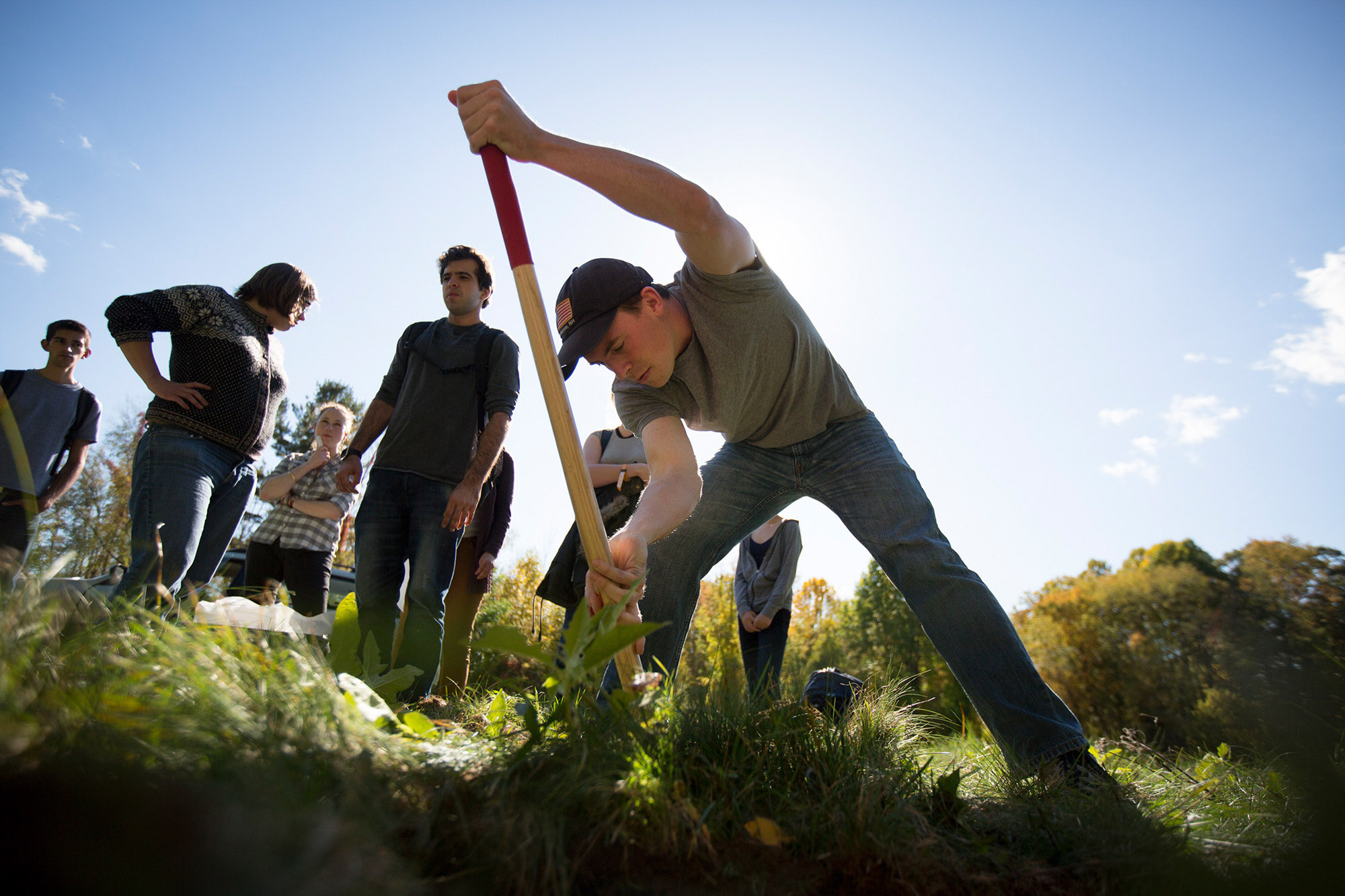 Student researcher dig a hole to plant a seismometer.