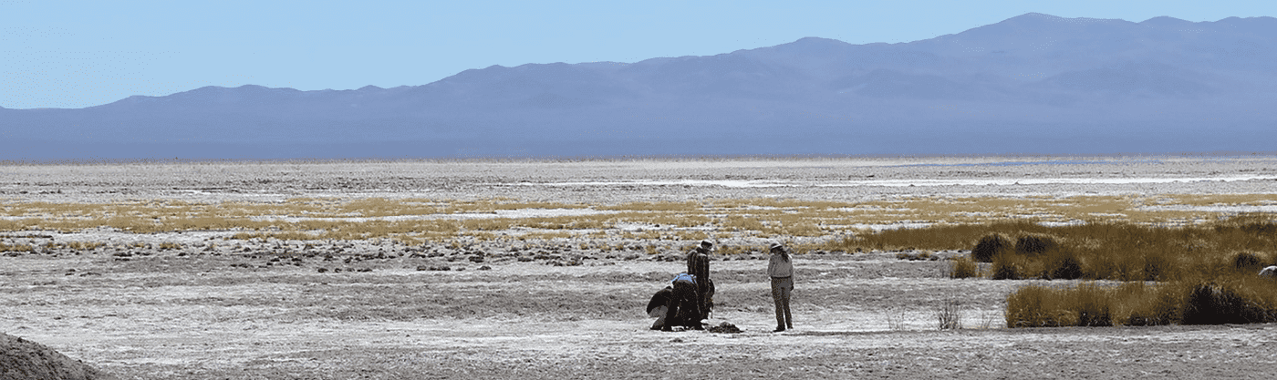 Desert location with four people in the foreground and mountains in the background.