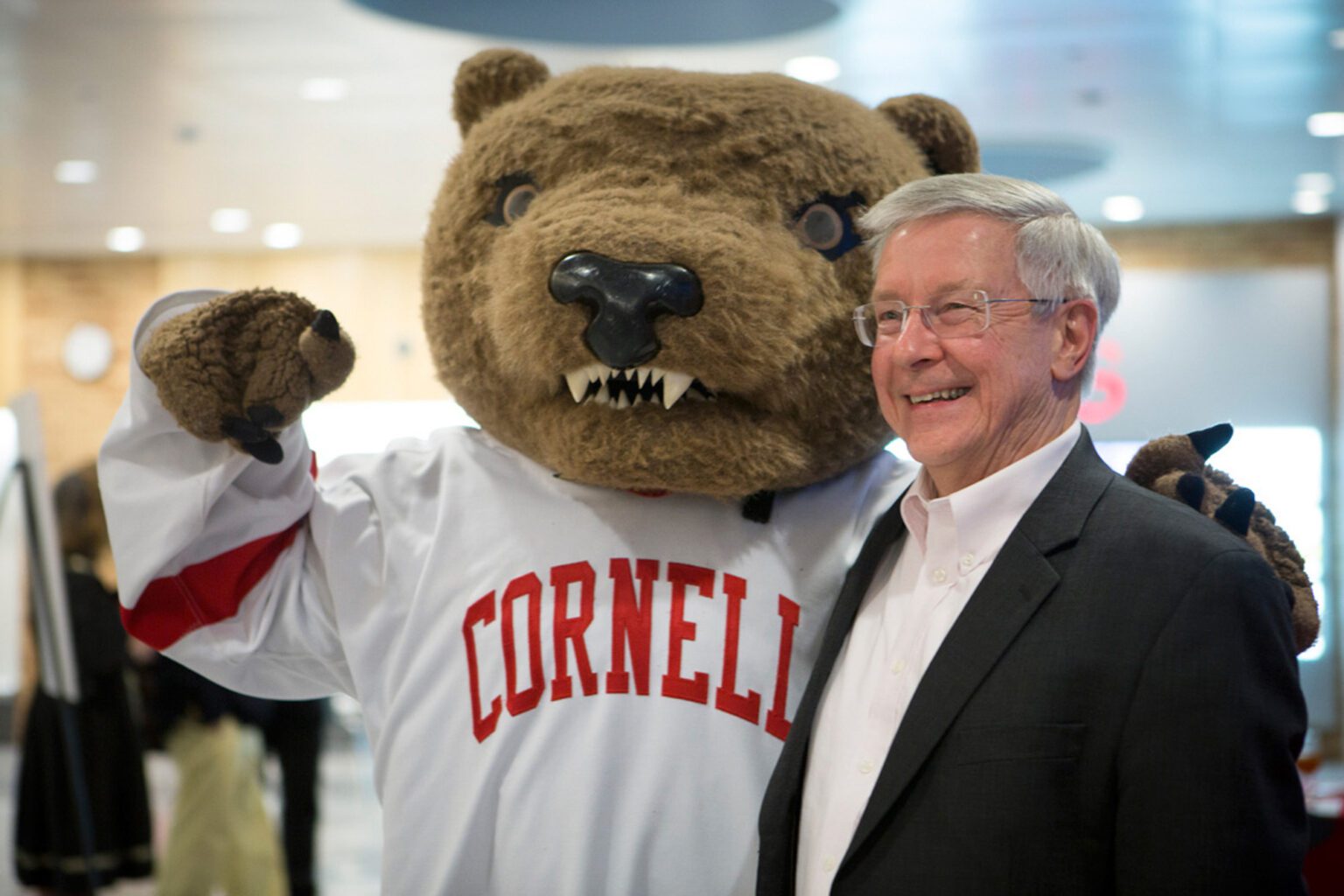 Cornell alumni Sam Dell poses with Cornell's Big Red Bear mascot.