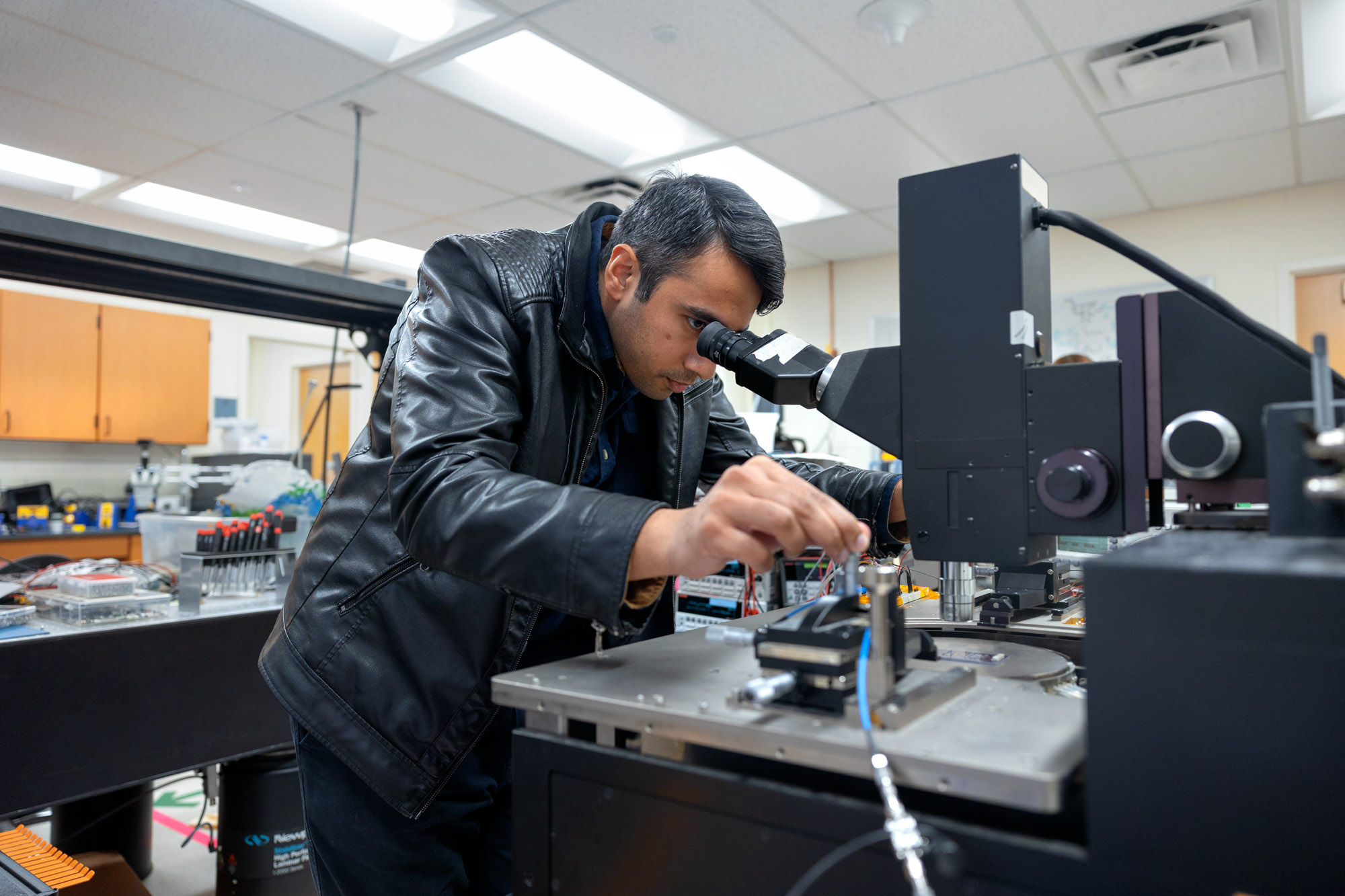 Post doctoral student, Bal Govind, looks through microscope in Apsel lab in Upson Hall.