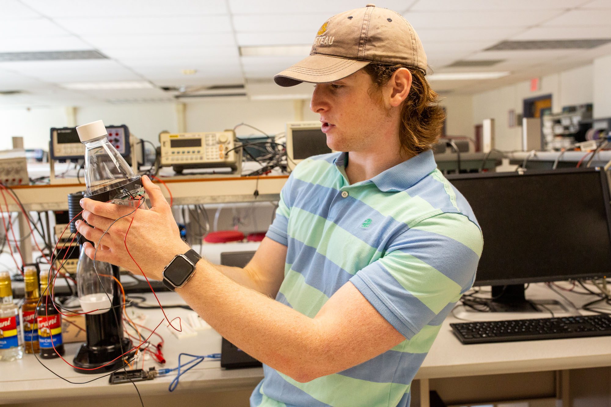 A student demonstrates the sensor project he designed with a soda stream