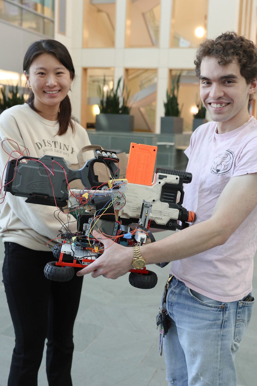 Students show off their robot in large atrium space