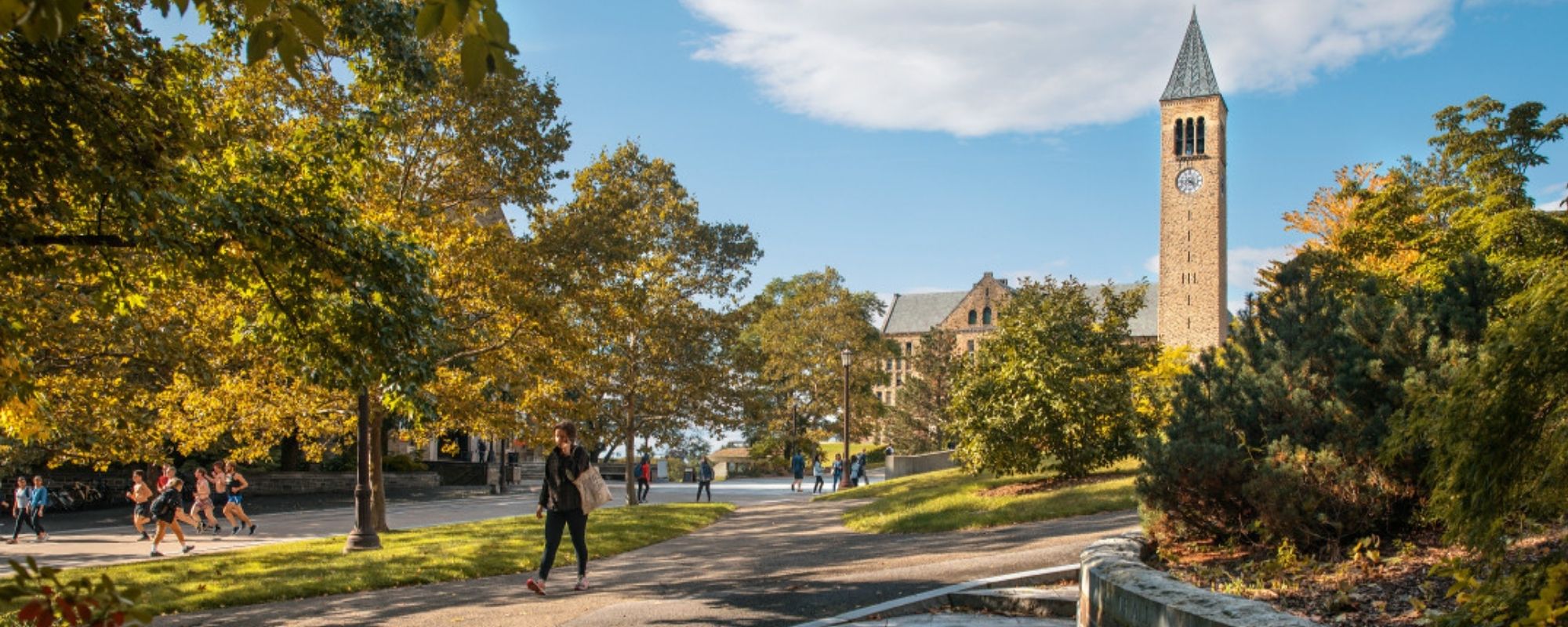 Scenic photo of students walking on campus with the clock tower in the background