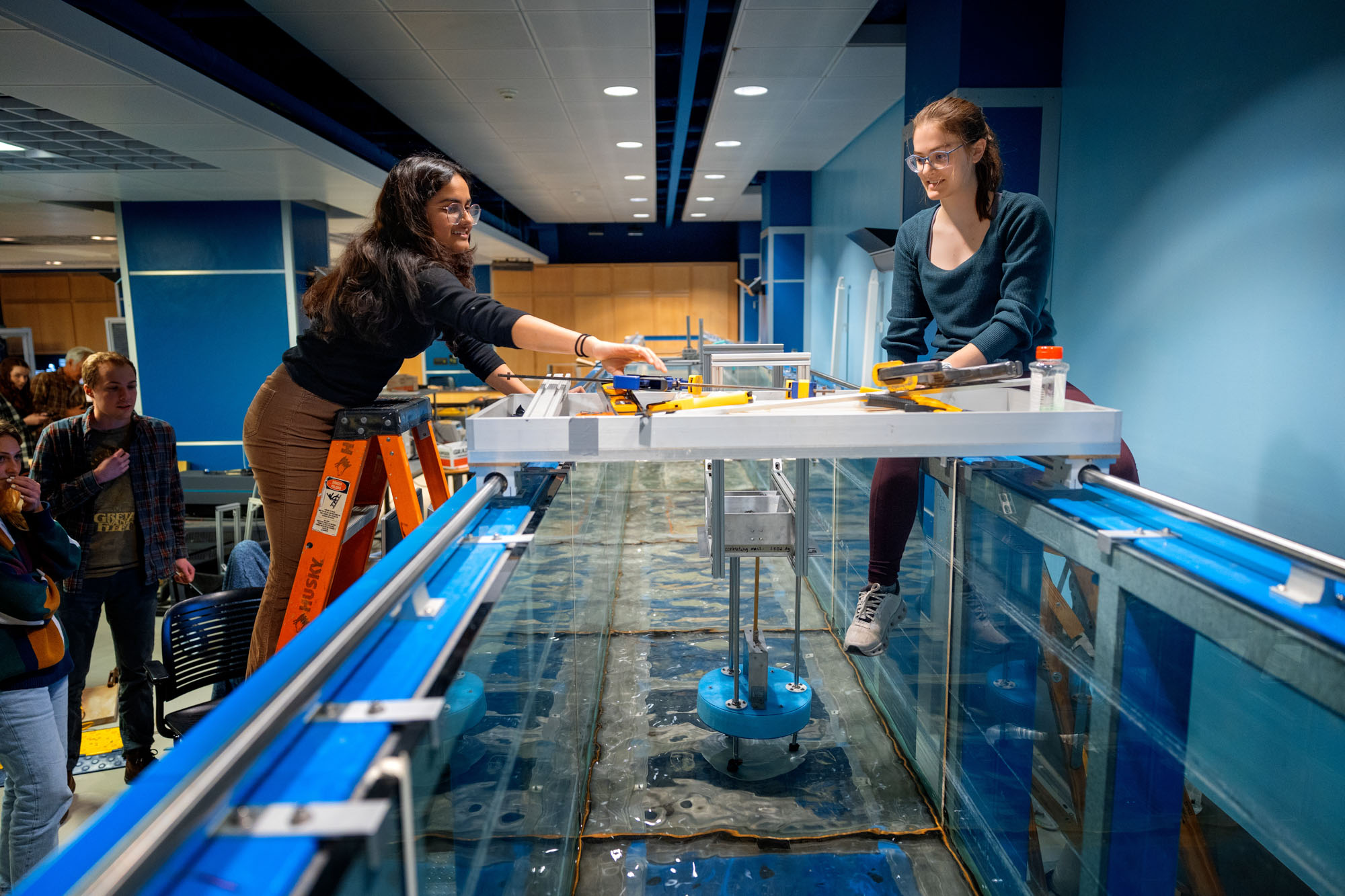 Kavya Mittha and Aisha Brundan test their wave energy conversion machine in the wave simulator tank in Hollister Hall.