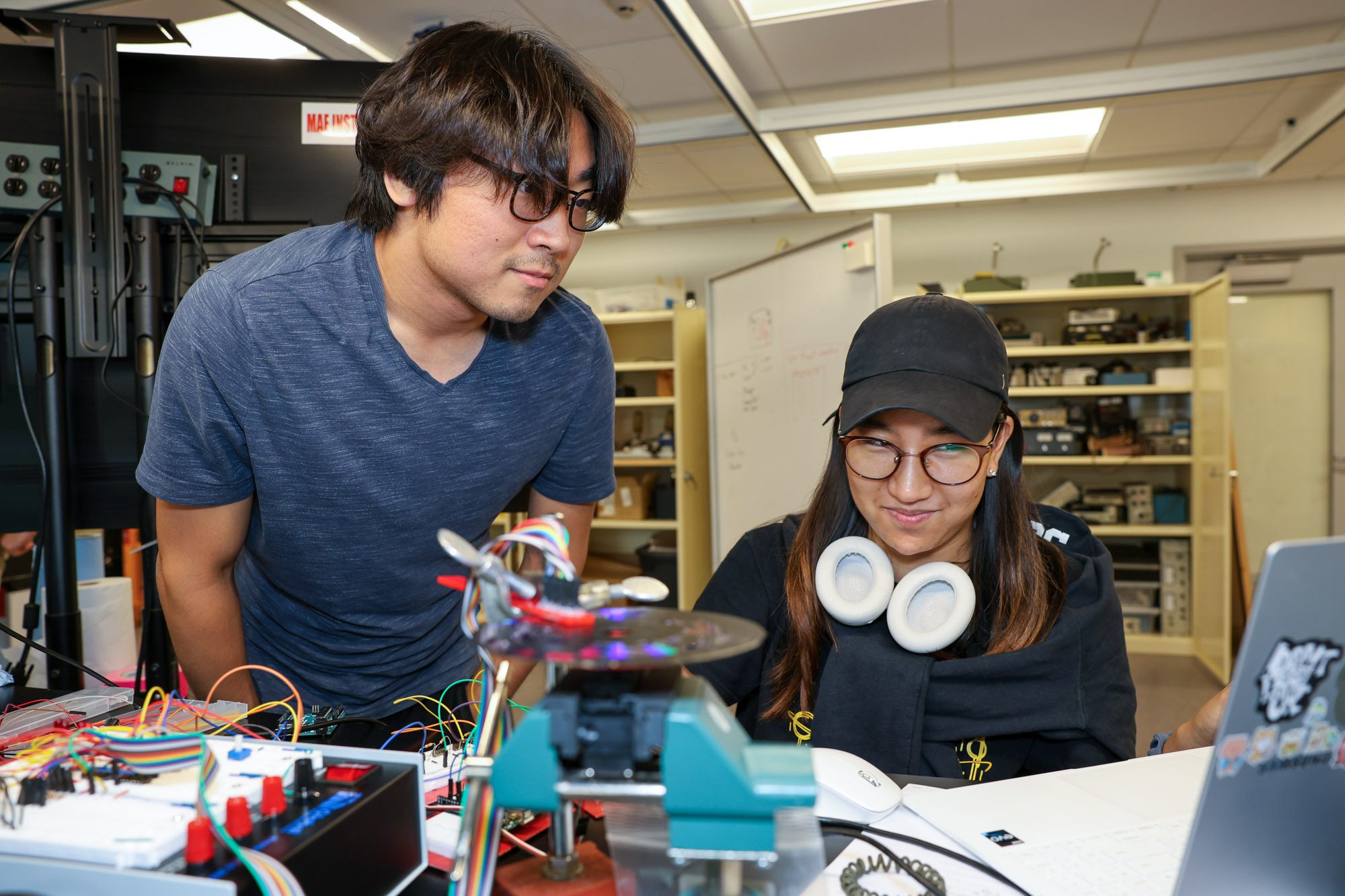 Two students look at mechanical equipment.