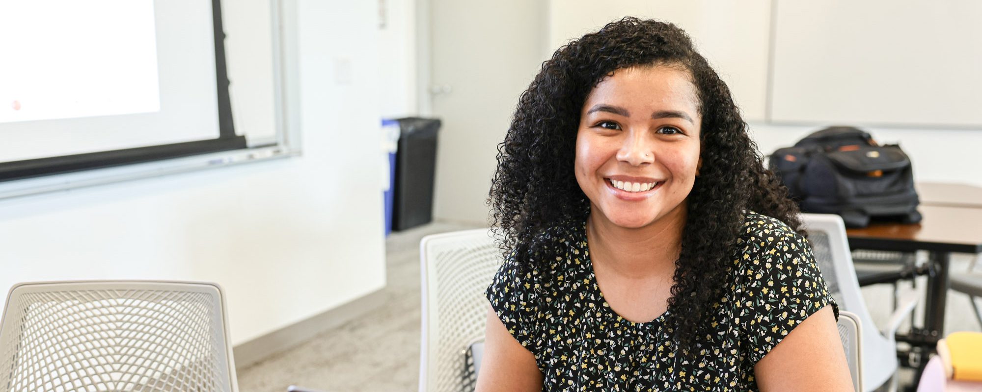 Smiling woman in front of a computer in a classroom