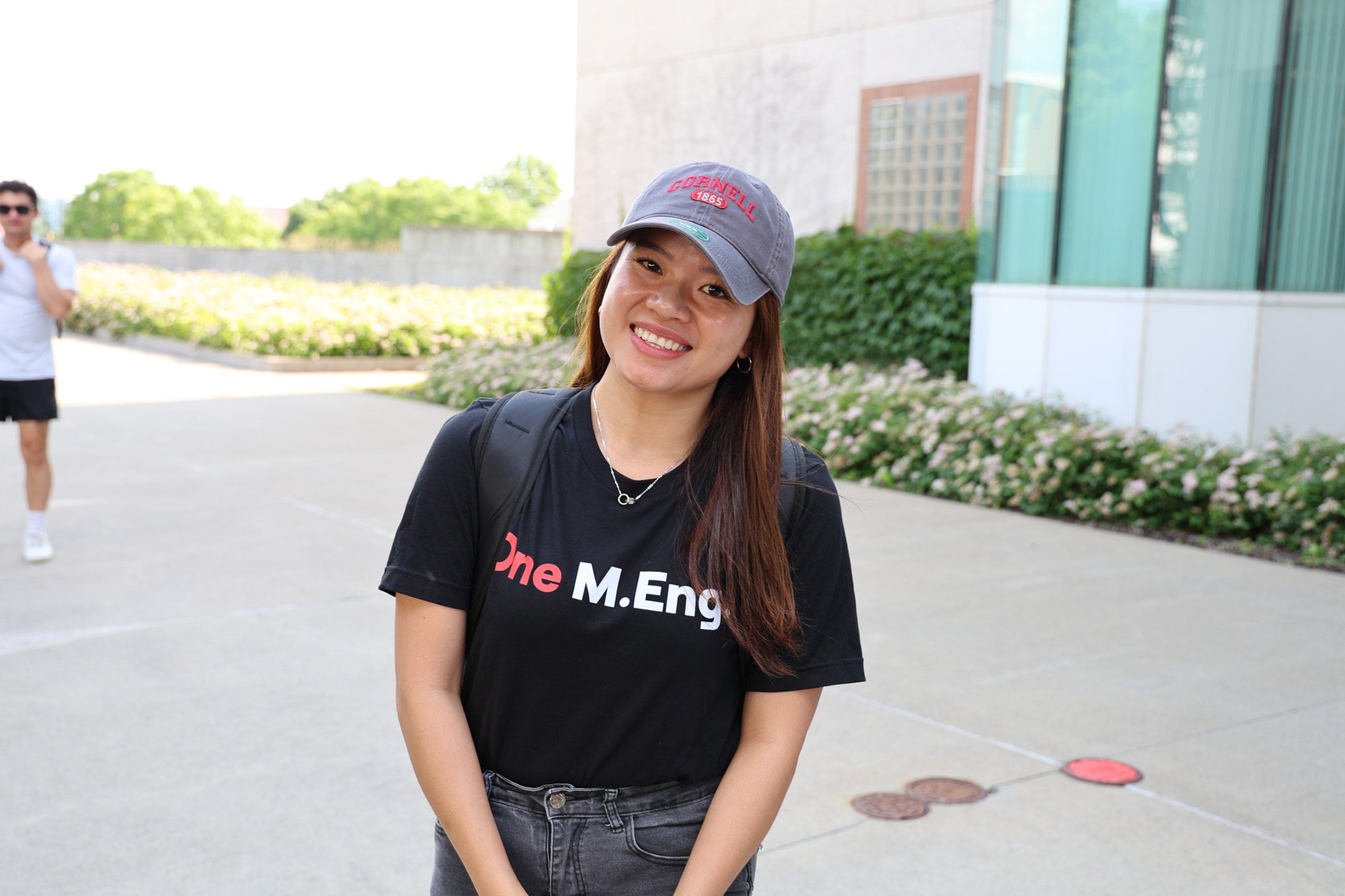 A student in a One M.Eng. t-shirt smiles for a photo